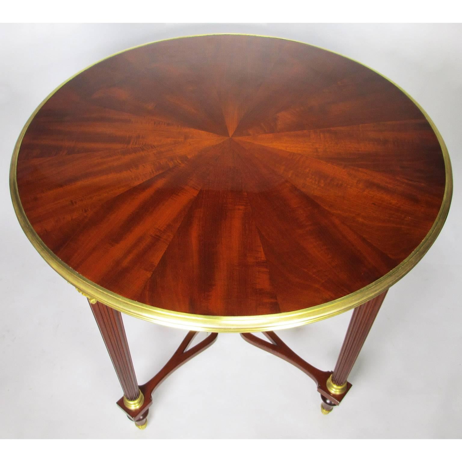 A very fine French 19th-20th century Louis XVI style mahogany and gilt bronze-mounted circular side table (Gueridon) by Maison Jansen, Paris. The tapered fluted legs fitted with classical ormolu capitols descending into a sunburst shaped stretcher