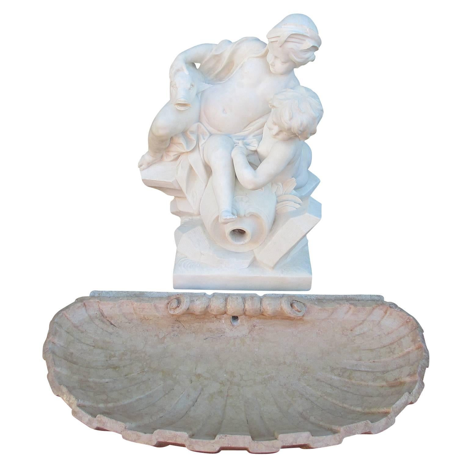 Charmant groupe de fontaines de jardin allégoriques en marbre blanc sculpté du XIXe siècle français, représentant deux putti enjoués assis sur un affleurement rocheux, avec une amphore renversée supportant un poisson stylisé, percée pour l'eau,