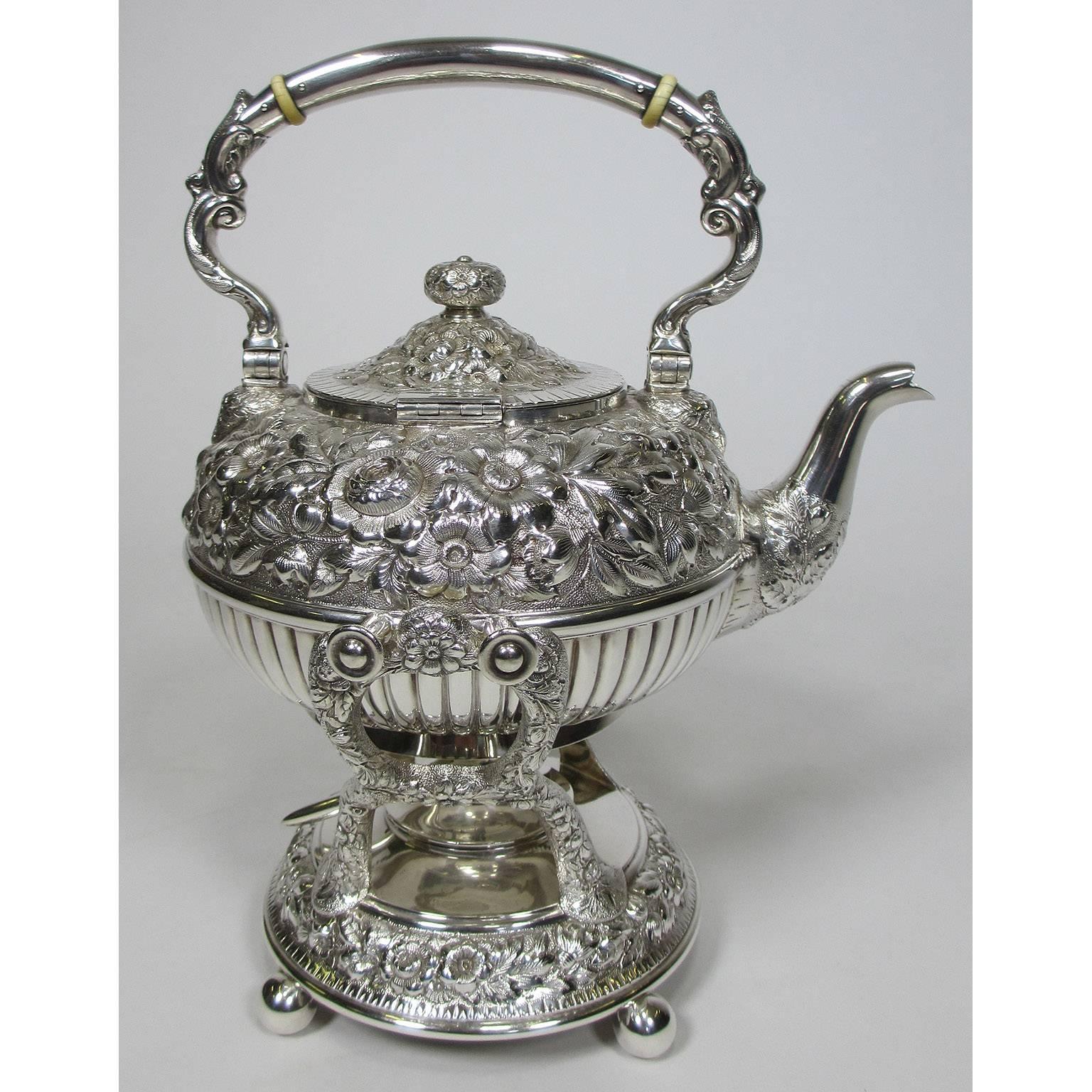 A very finely chased sterling silver six piece tea and coffee service by Geo C. Shreve & Co. Each finely embellished silver piece chased with floral and scrolled decorations. Comprising of a hot water samovar with burner, a coffee pot, a tea pot, a