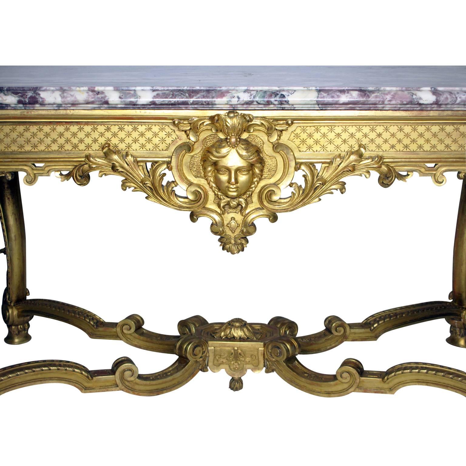 A very fine French 19th century Louis XV style giltwood carved figural center or hall table fitted with a Brêche violette marble top. The rectangular frame with four scrolled cabriole legs ending in hoof feet and conjoined with a center stretcher
