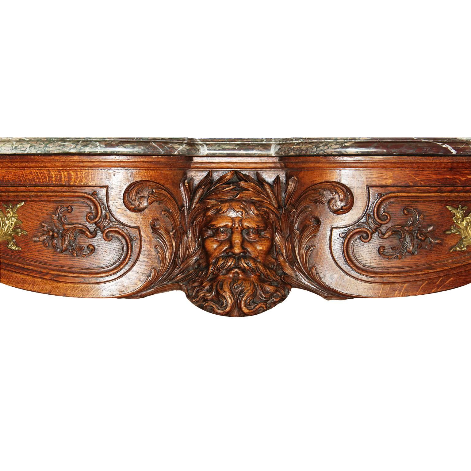 French Baroque 19th century Louis XV style finely carved walnut figural buffet server console with a variegated Rouge Royal marble top, the apron centered with a relief carved figure of an allegorical Neptune flanked by a pair of drawers with carved