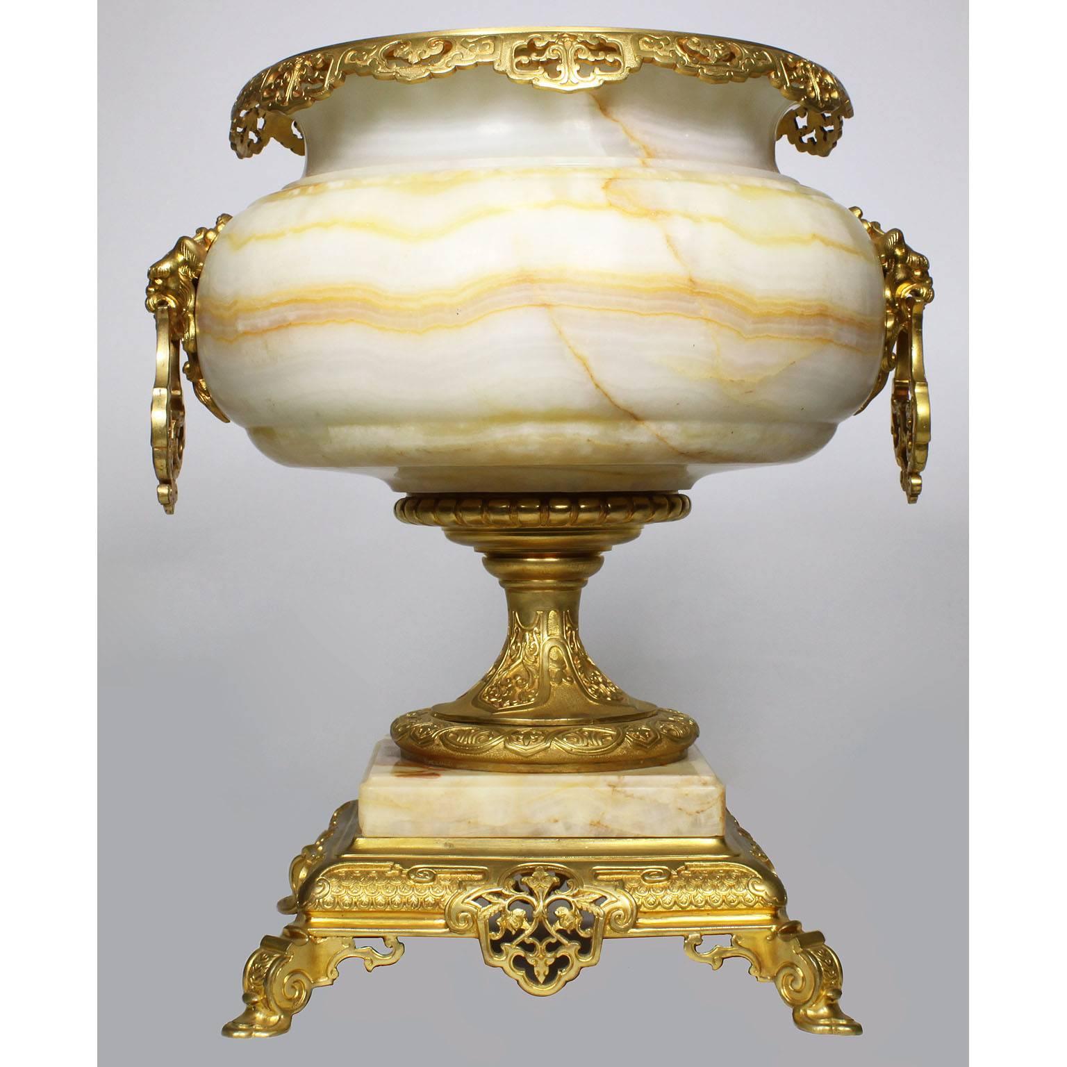 A large and impressive French 19th century onyx and ormolu-mounted Orientalist style figural urn, Attributed to Eugène Cornu (French, d. 1875) and G. Viot & Cie. The single ovoid onyx urn surmounted with lion masks attached to handles, the top rim
