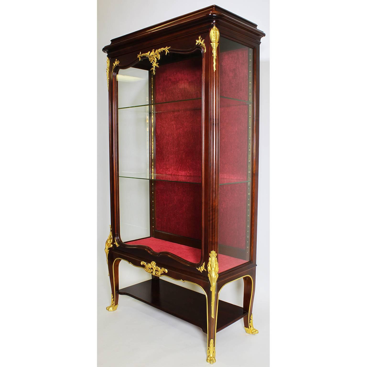 A fine French 19th-20th century Louis XV style mahogany and gilt bronze-mounted Vitrine by Haentges Freres. The single door cabinet surmounted with ormolu mounts with floral motifs, raised on four cabriolet legs with corner mounts with lion paw