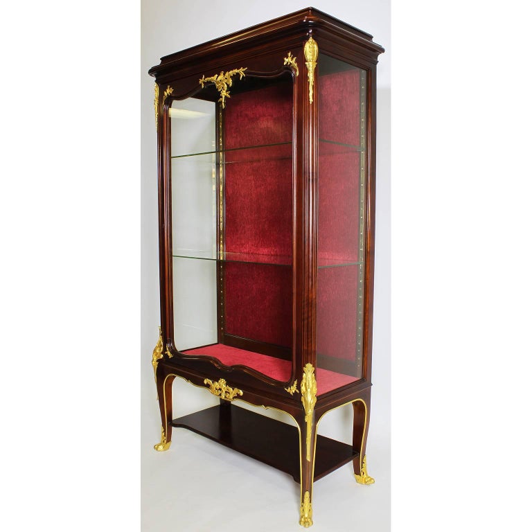 A fine French, 19th-20th century Louis XV style mahogany and gilt bronze-mounted Vitrine by Haentges Freres. The single door cabinet surmounted with ormolu mounts with floral motifs, raised on four cabriolet legs with corner mounts with lion paw