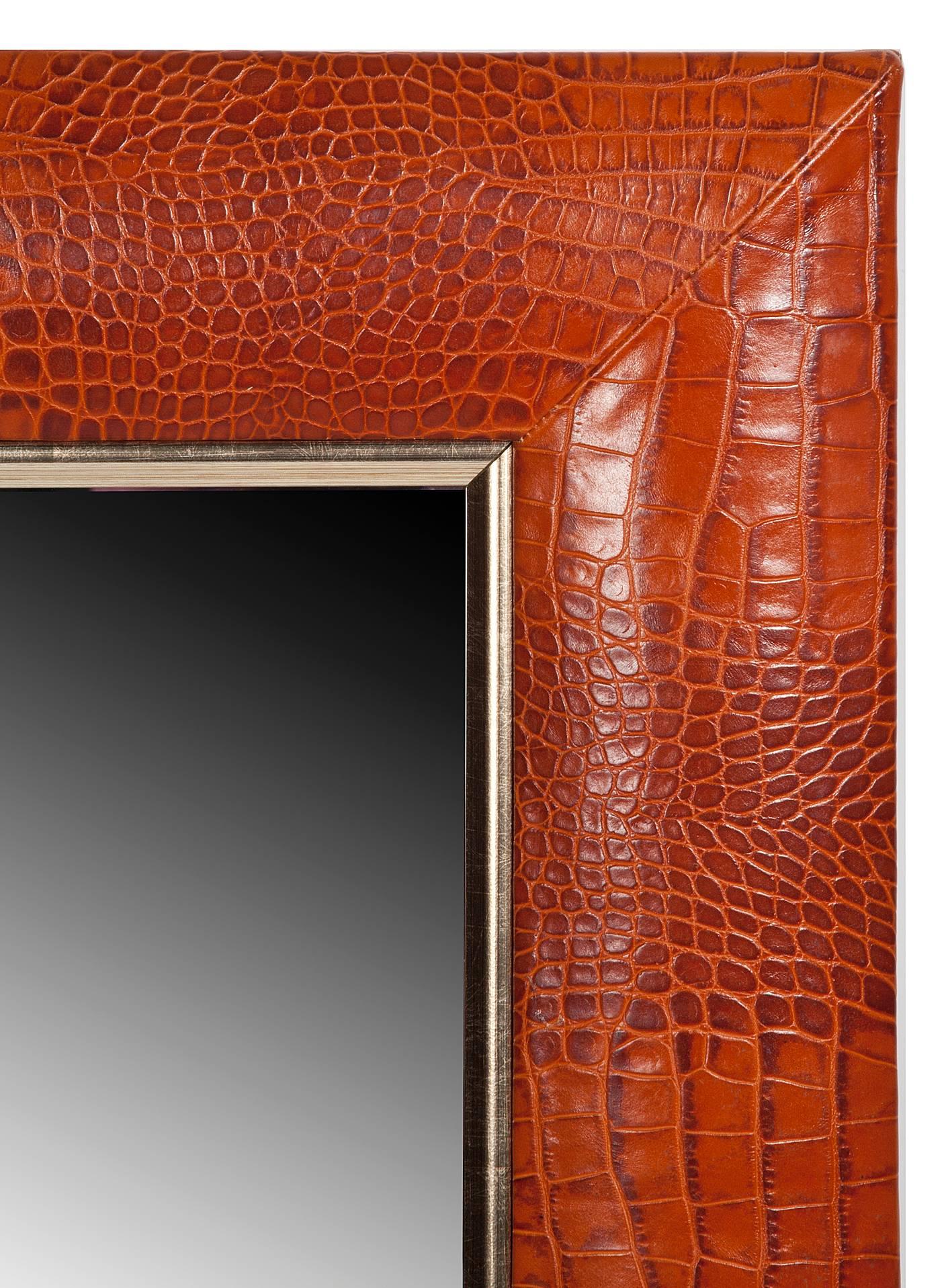 Cognac embossed crocodile Italian leather with champagne gold detailing.
1 ¼” beveled mirror.
4” wide leather frame.
Hand-stitched corners.
Measurements including frame: 24” W x 28” H x 1” D.

Made in the USA.
Custom and made to