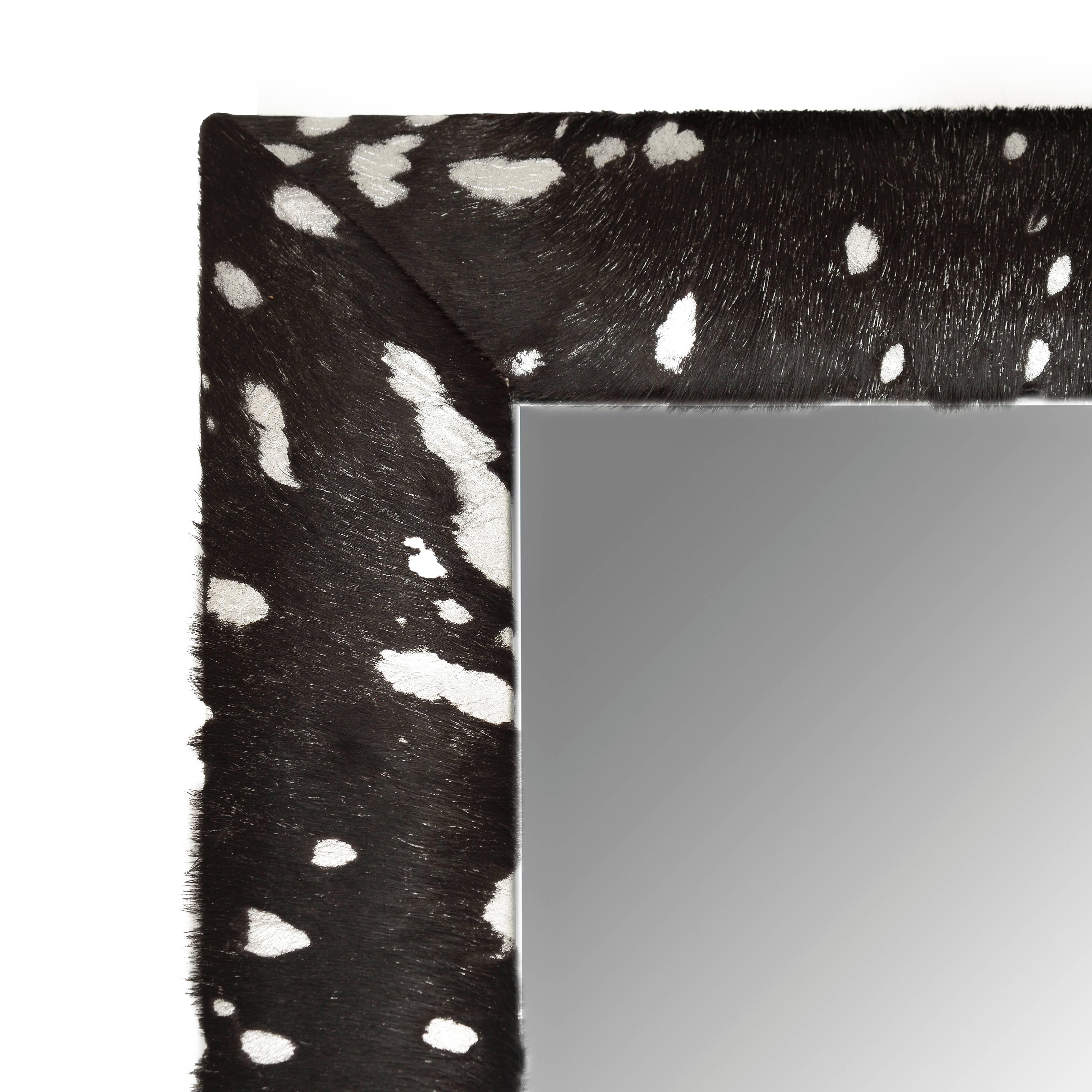 Contemporary black cowhide hair with silver metallic acid wash splash framed beveled mirror by KLASP home.

Made by skilled professional craftsmen.
1 ¼” beveled mirror.
4” wide leather frame.
Hand-stitched corners.
Measurements including frame