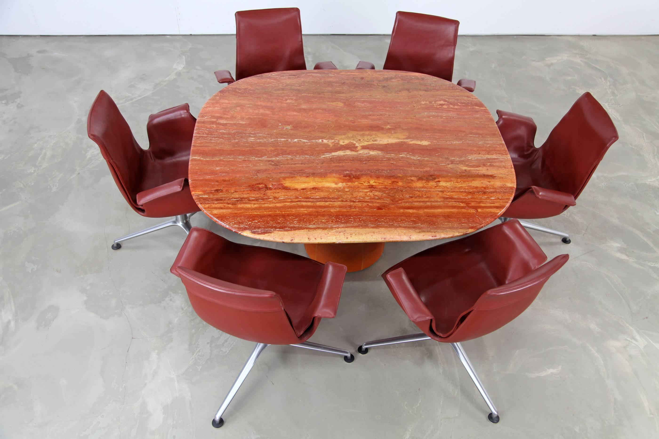 Extravagant table made by B & B Italia. This piece features a top made of red travertine and a base wrapped with leather. It's in excellent condition.