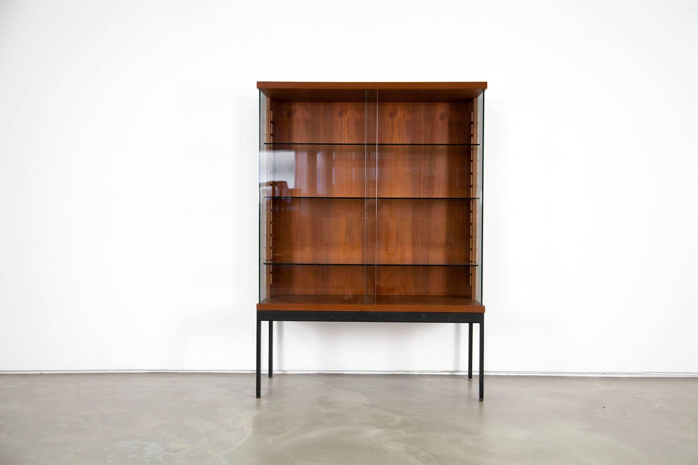 A rare piece of furniture from the early 1960s. The display is veneered with teak and features glass sliding doors.