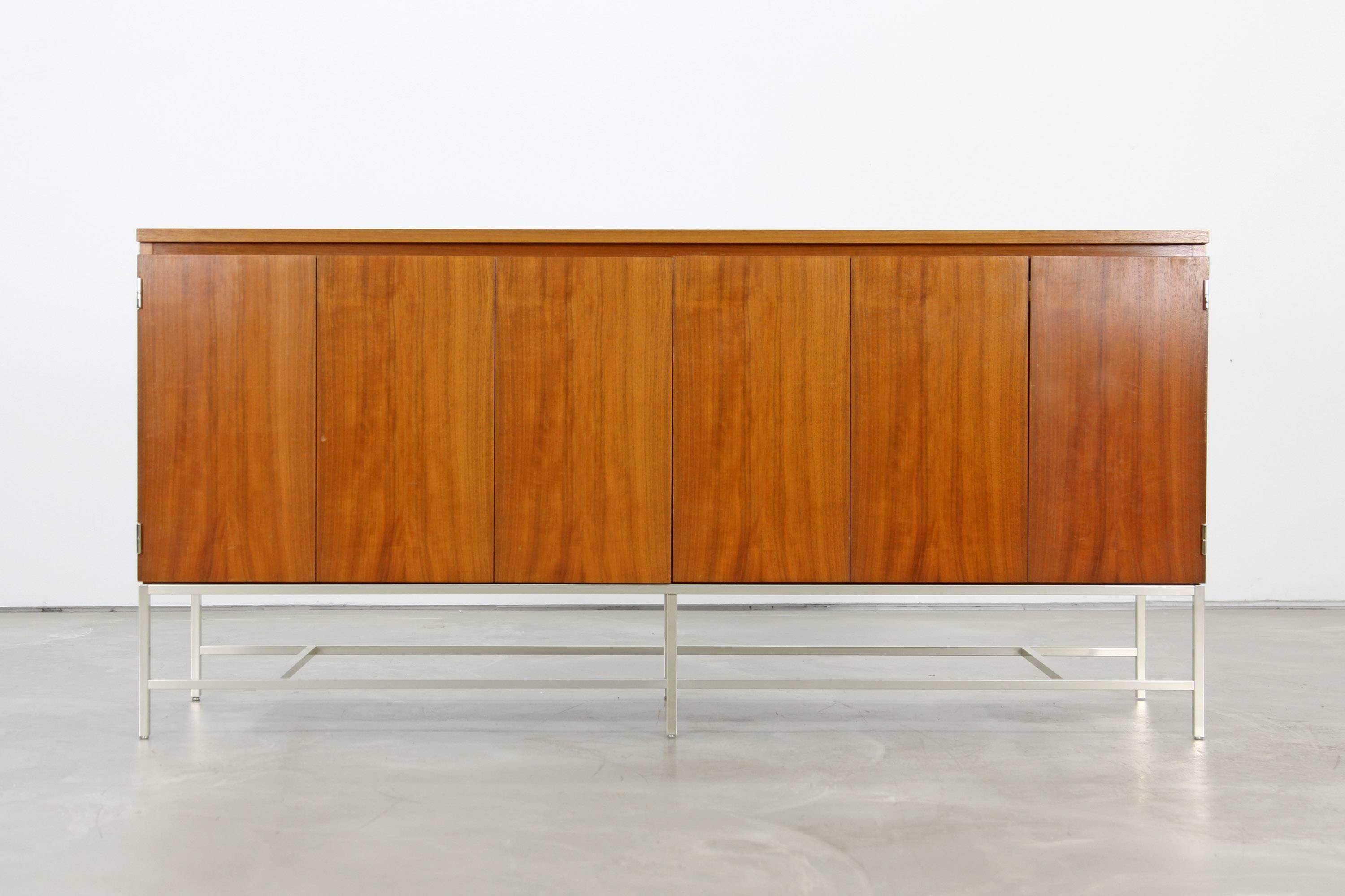 Premium quality credenza by Paul McCobb for WK Stuttgart. This sideboard features folding doors and six drawers. Excellent piece in great condition.