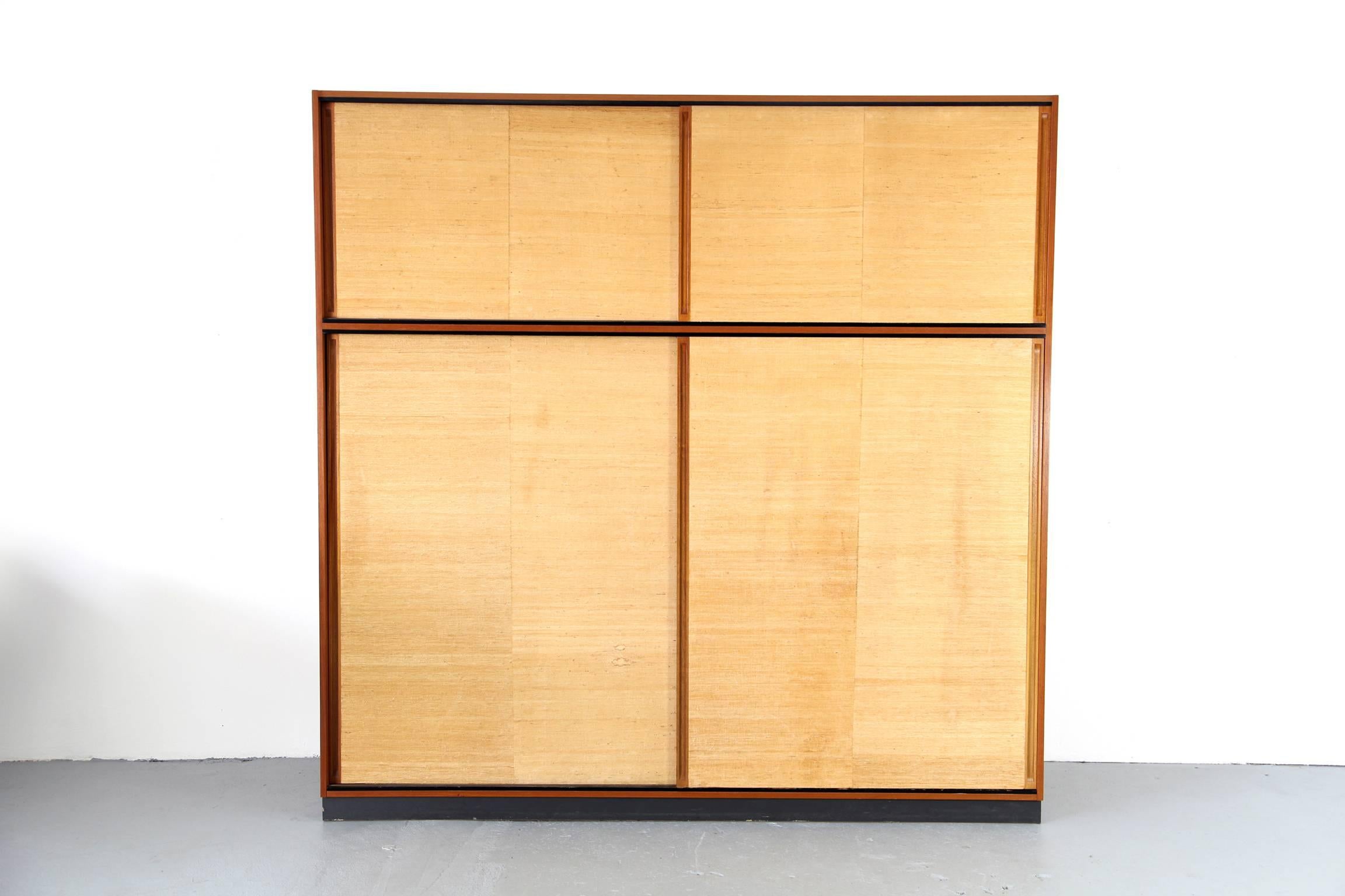 Rare wardrobe by Dieter Waeckerlin for Behr Möbel, Germany. Body made of teak, sliding doors covered with fine seaweed. Very practical layout of the compartments.
 