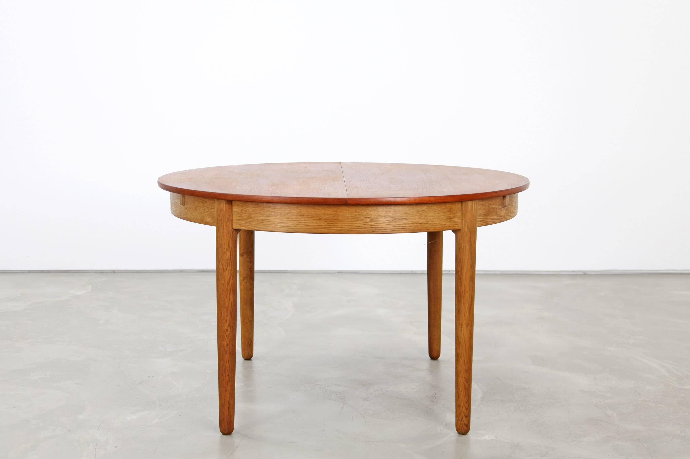 This danish dining table by Hans Wegner for Andreas Tuck shows excellent craftsmanship and is made of teak and oak. It features one extension leaf. It extends to 182 cm/ 71.75".