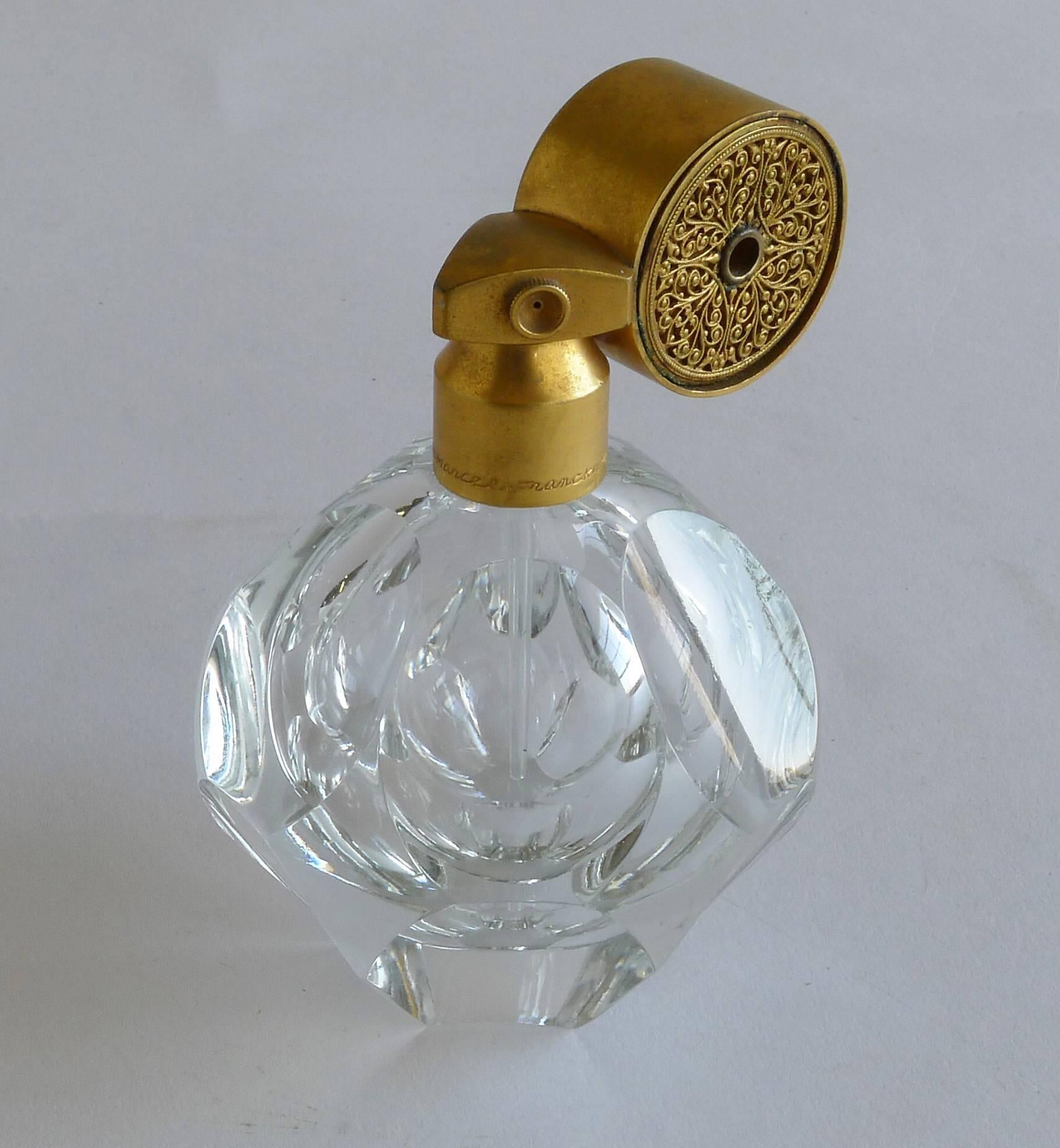 Glass and gilt metal perfume bottle, Art Deco. With round faceted ball shaped bottom and round applicator with very detailed interior pattern.