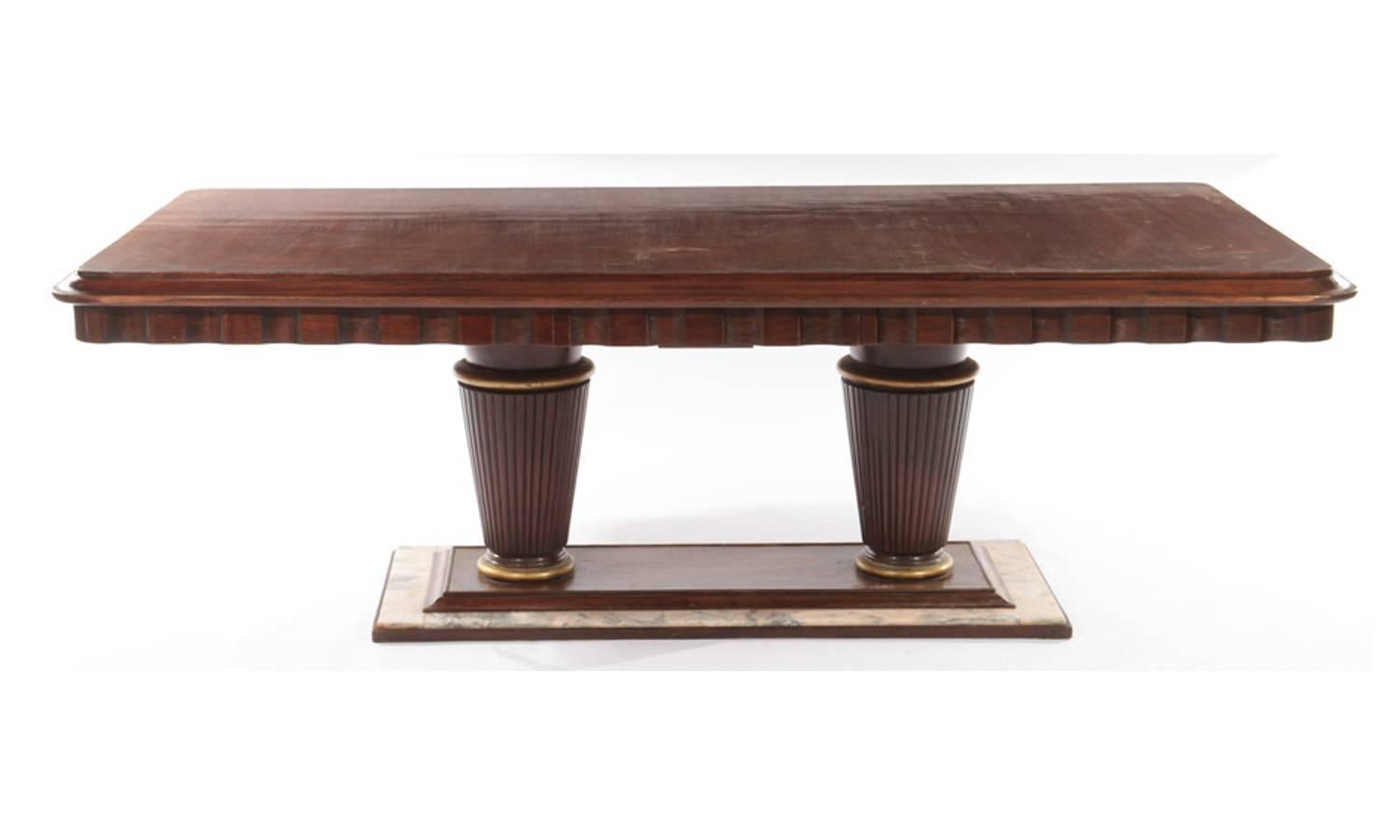 A mahogany and marble Art Deco dining room table, circa 1935. Continuous fluted top, with two large columns and marble as base. Has a storage drawer on 1 side. Could use some touchup and refinishing, this is reflected in the price.

Architect, Sandy