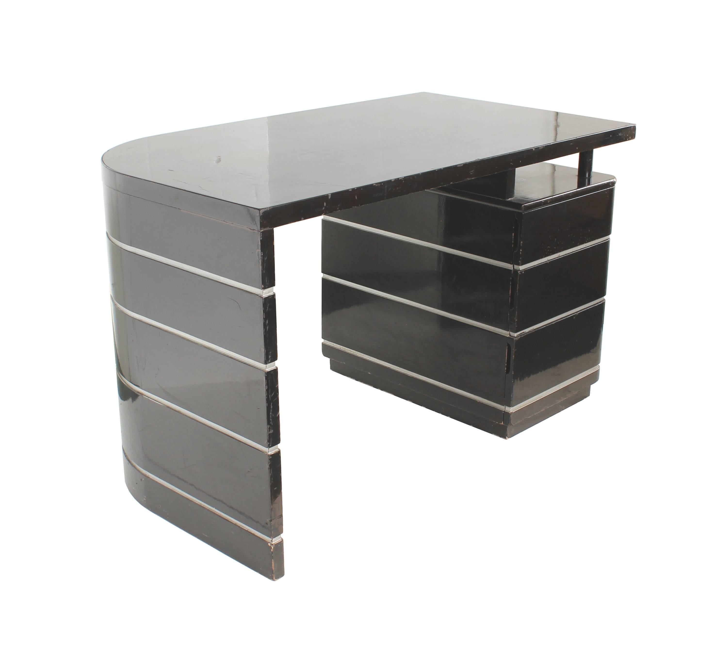 Curved desk in black lacquer silver grooves with drawers. Attributed to Paul Frankl. Classic Art Deco lines. Has three drawers. Lacquer has some chips and scratches, especially along the edges. Structurally sound.

Architect, Sandy Littman of