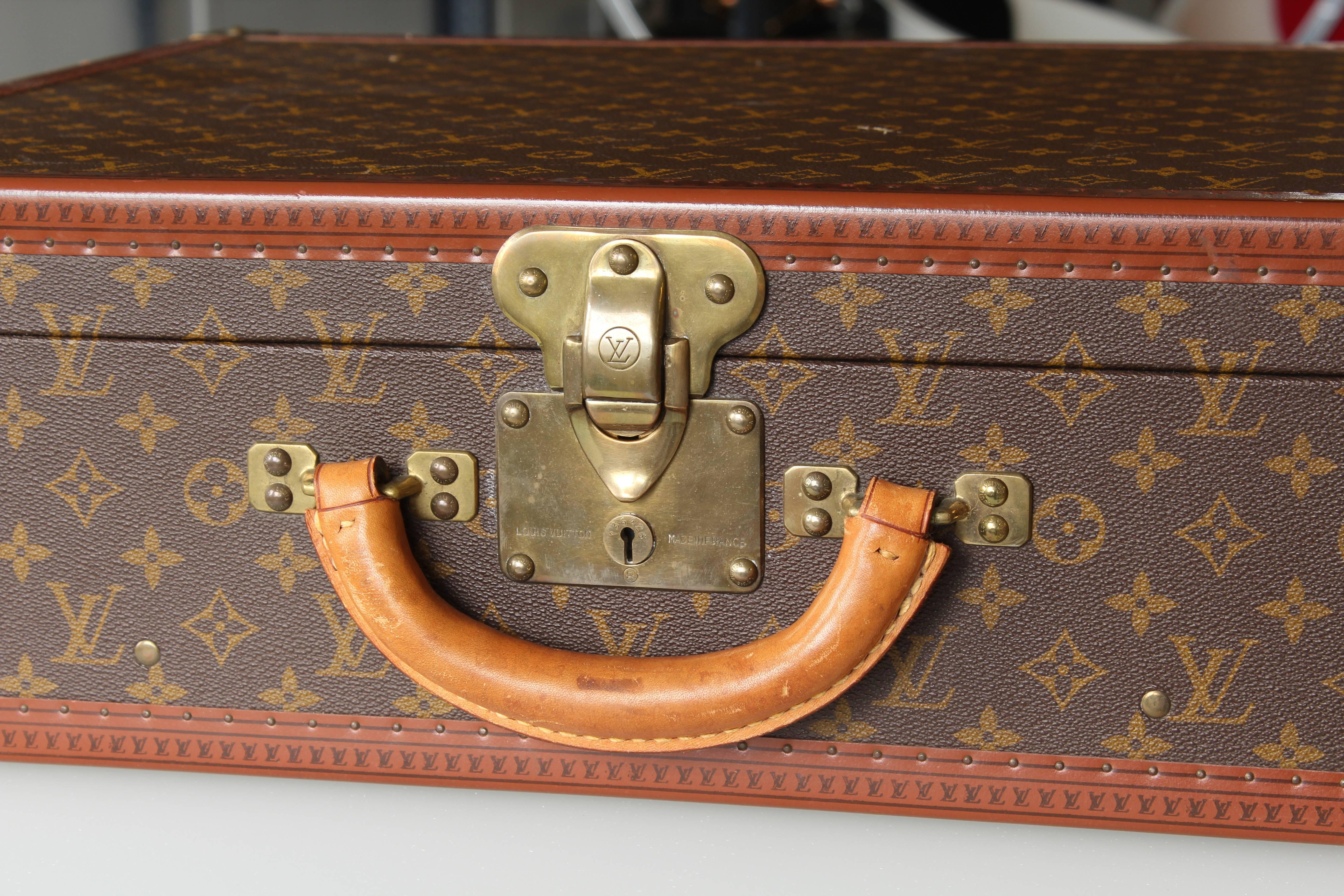 Vintage Louis Vuitton suitcase leather and brass. Has marking stamp on interior (see photos). It's sticker number is Louis Vuitton #910990, with its interior and exterior in good condition. Interior has fold down panel held in place by two