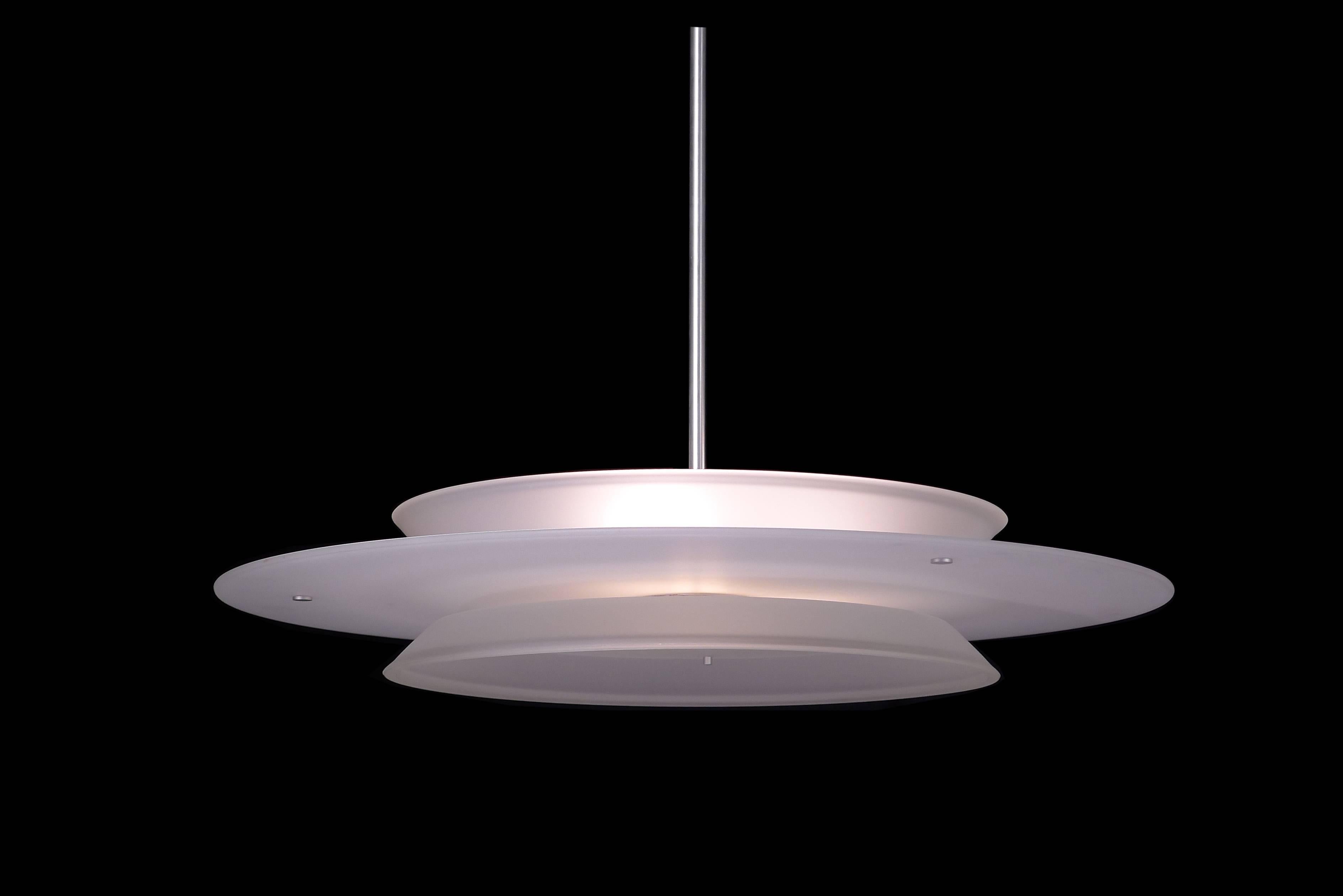 3' diameter spaceship pendant with white glass center disk with tapered clear frosted glass top and bottom. Metalwork is brushed aluminum.  Designed by Architect, Sandy Littman.

Architect, Sandy Littman of Duesenberg LTD.  and The American Glass