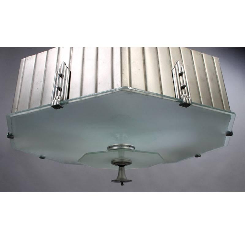 Octagonal chandelier with fluted/scored aluminum side panels and beautiful small castings which secure bottom glass panel. Rewired for (4) 75 watt incandescent a lamps. Measures: 33 inch diameter. Main photo shows an optional updated satin aluminum