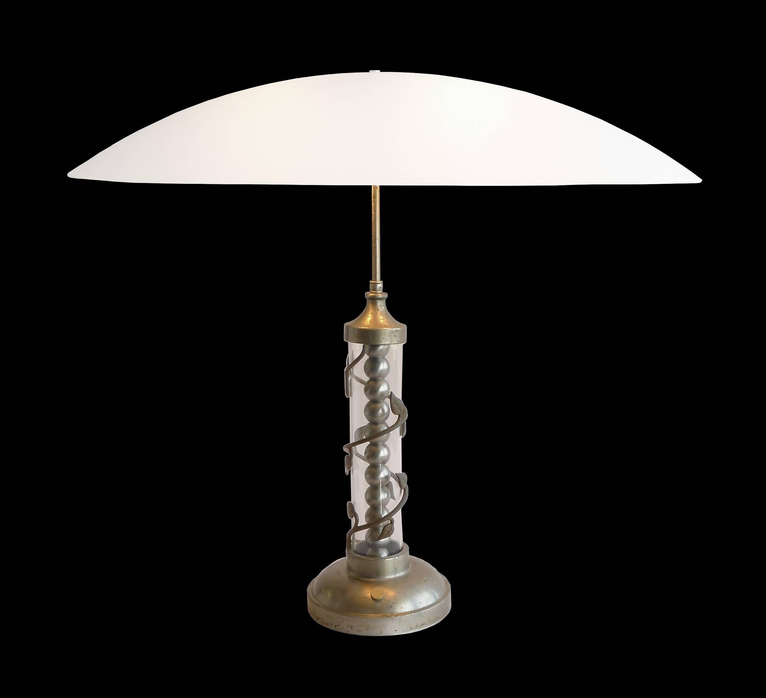 Hollywood Regency table lamp from the 1940s. Has clear glass center column surrounded with leaf and vine motif. Stacked nickel ball detail within clear glass tube. Manufactured in Brooklyn. Wired for two incandescent sockets with silver cord and