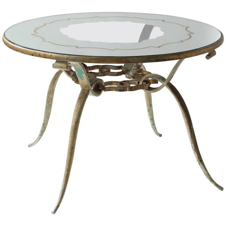 1940s four-leg mirrored coffee table. Mirrored top has a designed pattern which mimics the metalwork below. Slender round legs end at top with scrolls. Gilt metal finish. Some wear. Included in this purchase is a pair of 1930s French Regency wall