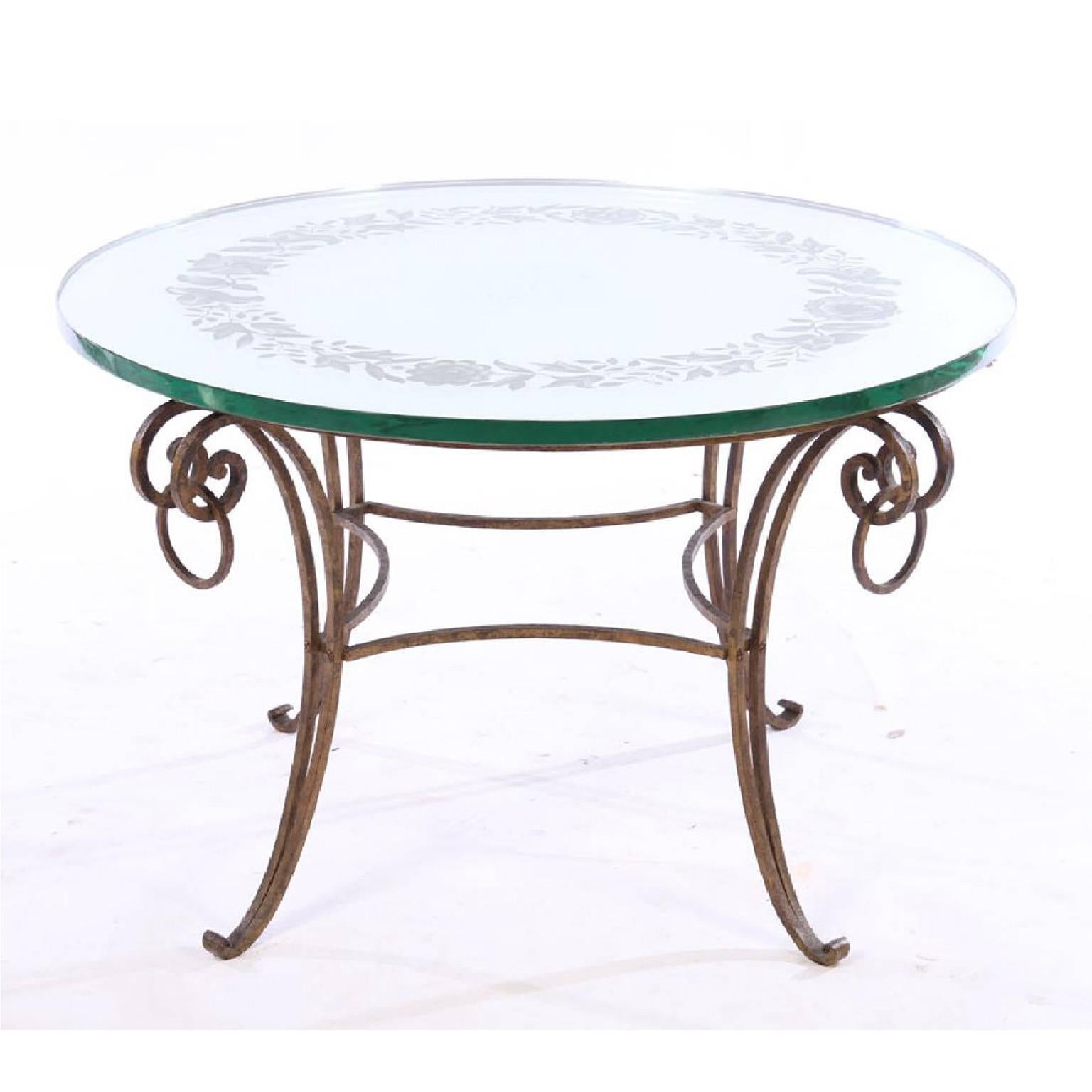 French mirrored coffee table in the style of Rene Drouet having etched floral decoration supported on wrought iron base. Mirrored top is 1 inch thick. Sold as a set with gilt decorated wrought iron and crystal, eight-arm chandelier. Hollywood