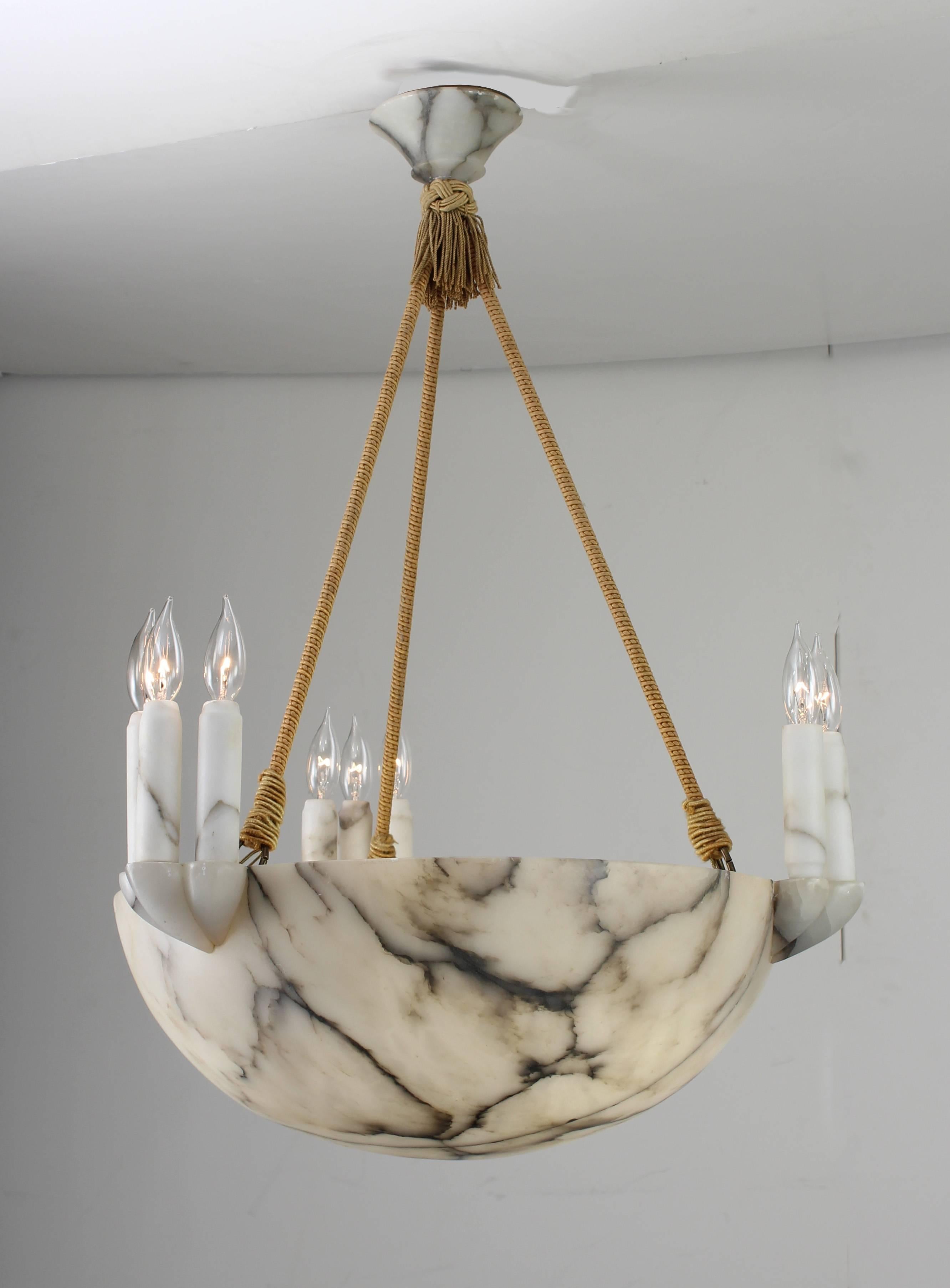 Art Deco Alabaster bowl pendant light. Outstanding variance in the veining and color of stone. Each set of three candles is supported by a carved alabaster form. Gold fabric tassel and suspension. Canopy is matching alabaster. Incandescent lamping,