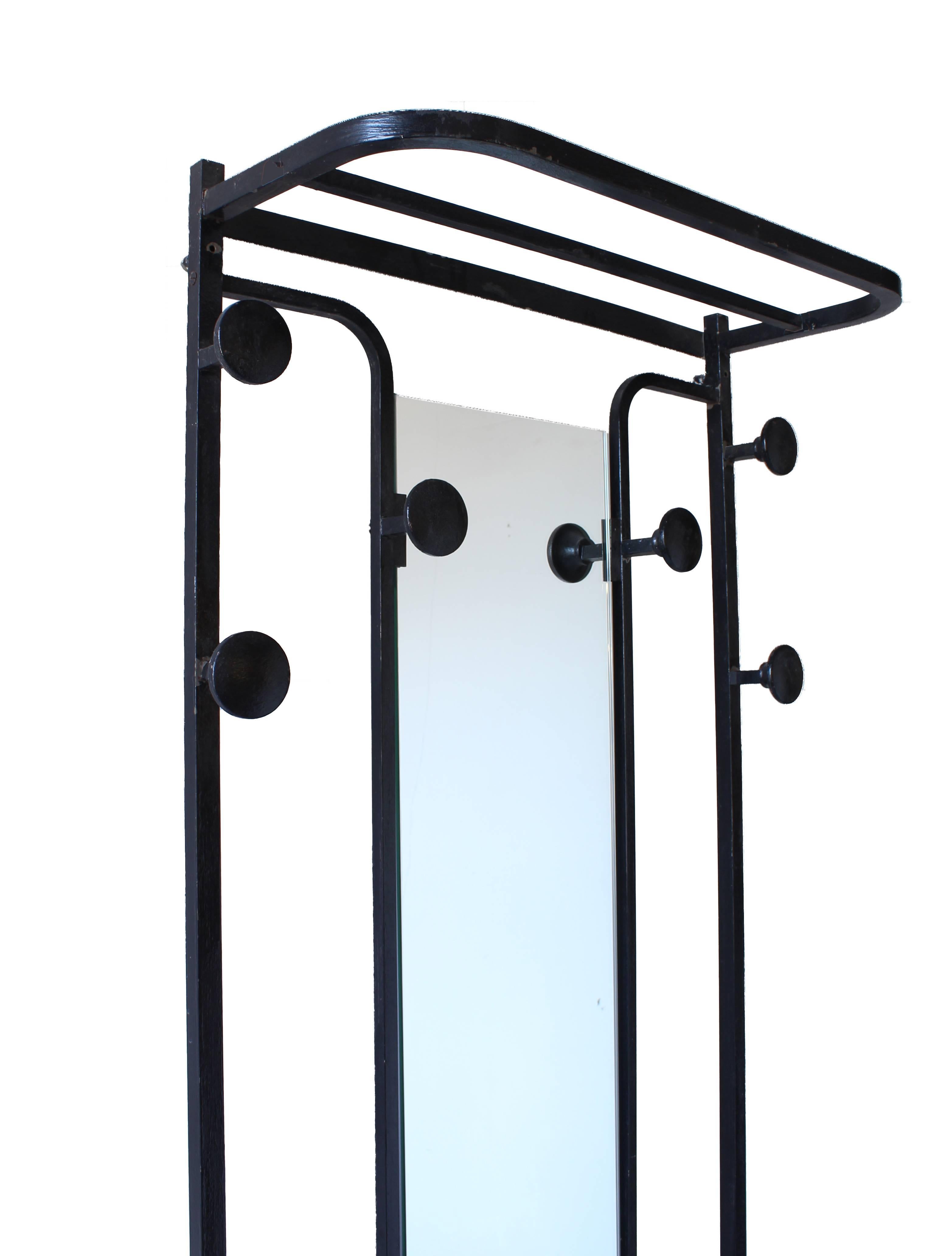 Coat rack in hand-painted black steel. Upper and lower shelves and six coat hanger knobs. Center mirror is new. Original wall mounting holes and standoffs at the top or rack.

Architect, Sandy Littman of Duesenberg LTD.  and The American Glass Light