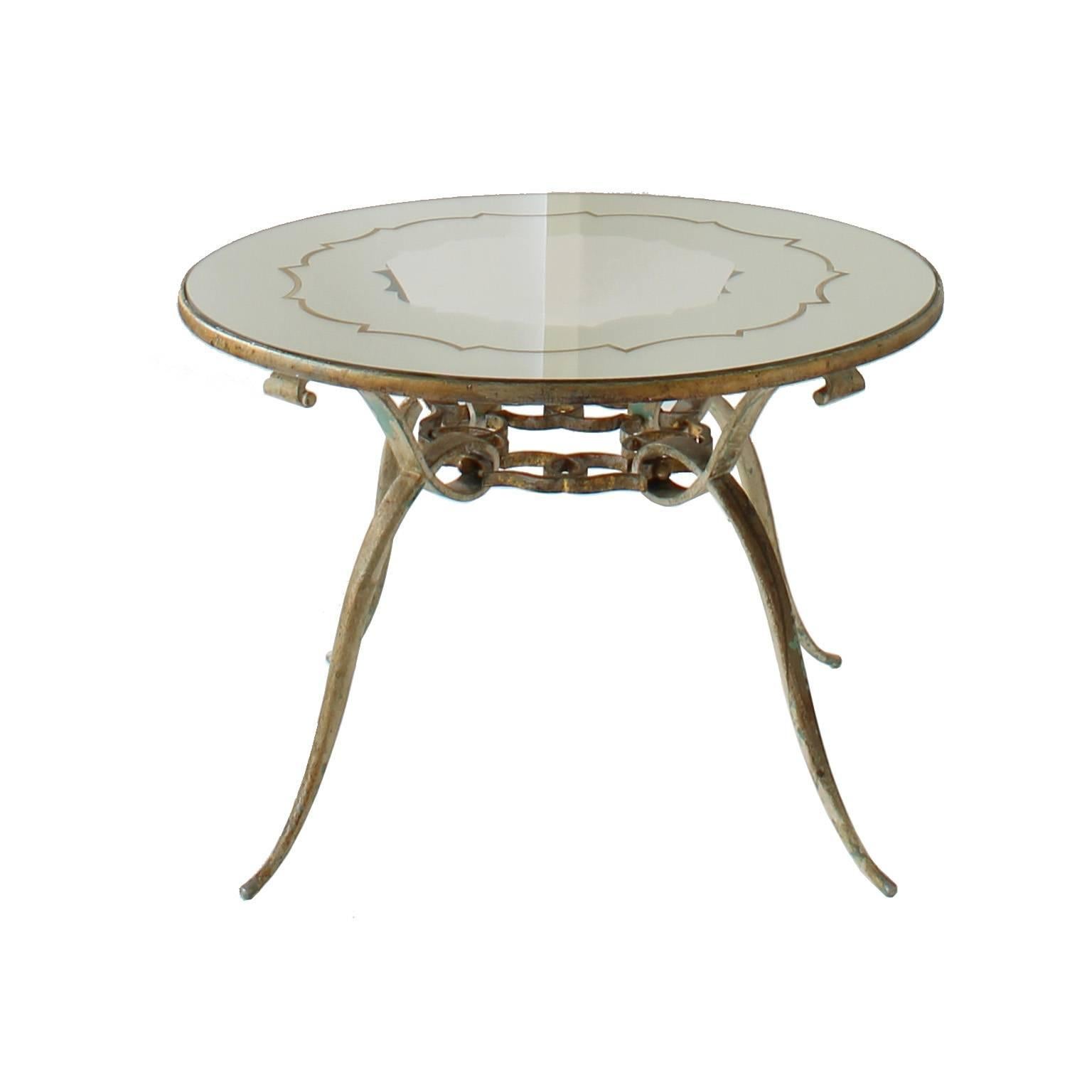 Four leg mirrored coffee table. Mirrored top has a designed pattern which mimics
the metalwork below. Slender round legs end at top with scrolls. Gilt metal finish. Some wear.

Architect, Sandy Littman of Duesenberg LTD.  and The American Glass