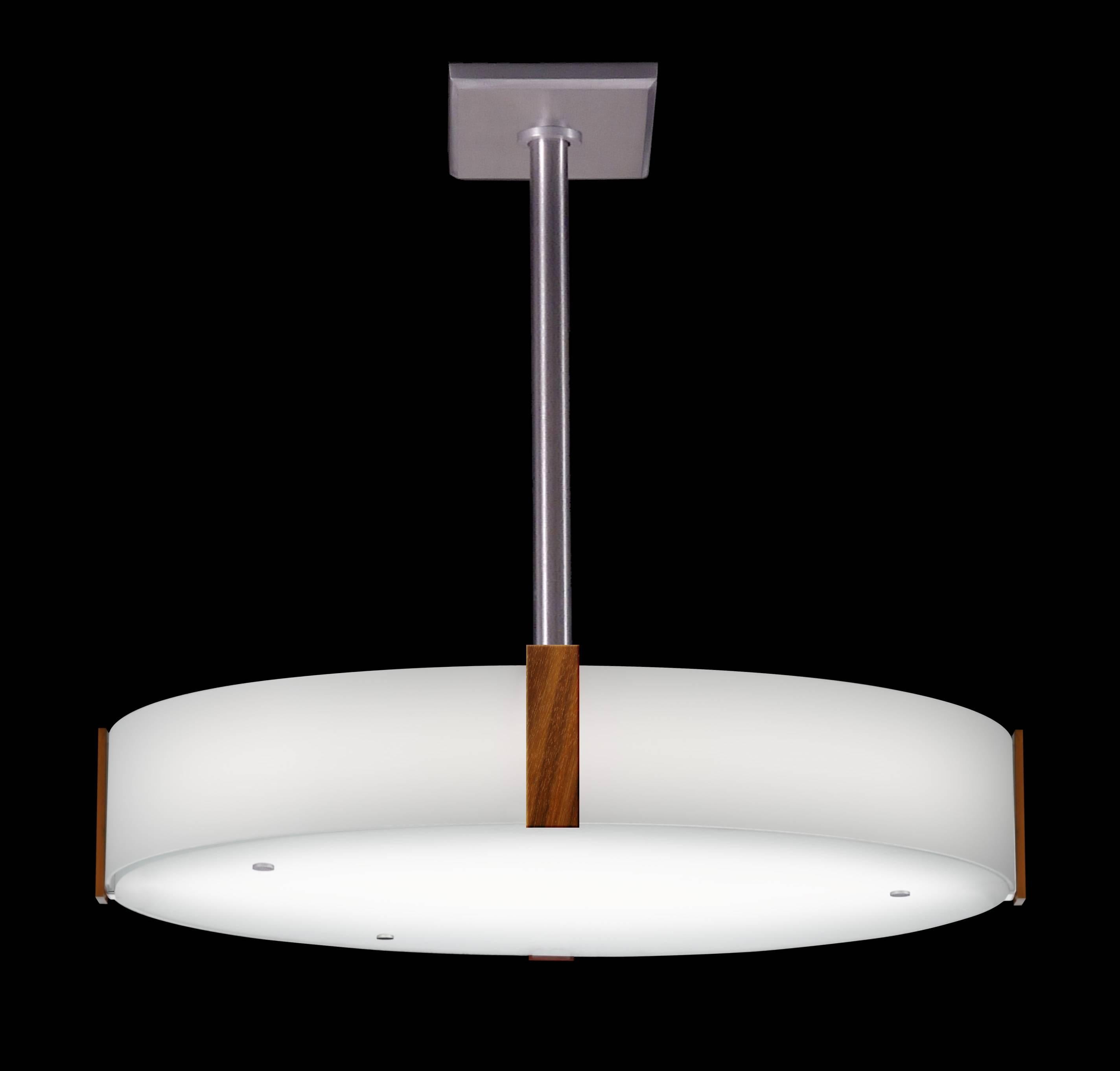 Round glass drum pendant light with curved glass sides and wood vertical details. Classic simple design lines in the manner of Mid-Century Modern. LED or incandescent lamping. Satin aluminum metalwork.

Architect, Sandy Littman of Duesenberg LTD. 