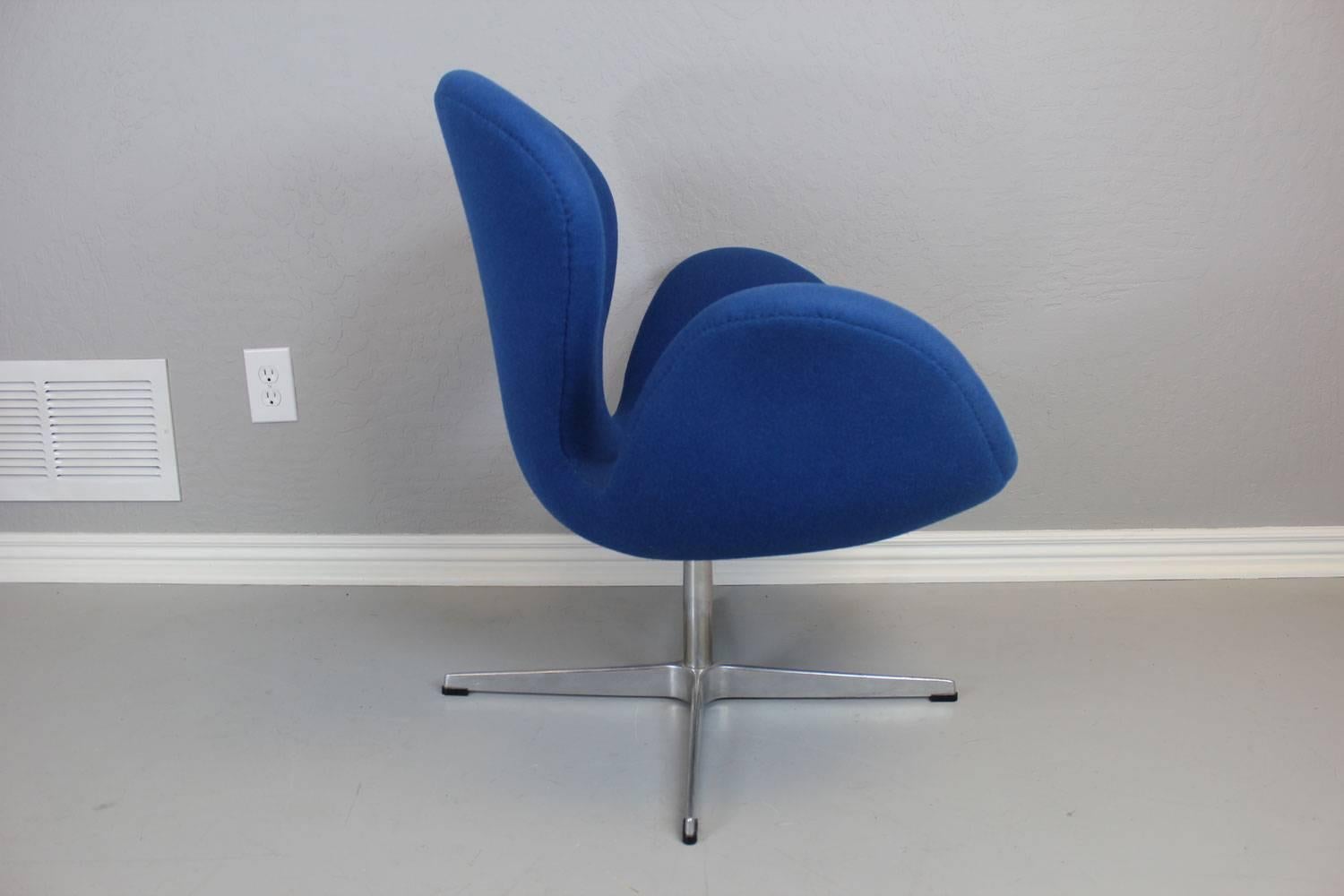 Arne Jacobsen designed swan chair manufactured by Fritz Hansen in Denmark. Original bright blue wool upholstery on an aluminium spindle foot print. Includes Fritz Hansen "Made in Demark" tag.