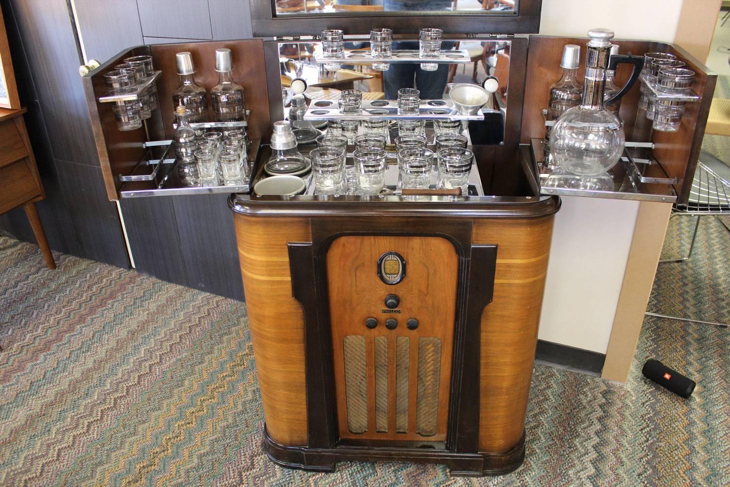 Rare Philco bar cabinet with built-in radio. Barware includes original Dorothy Thorpe glassware. Radio and two-lite bulbs are in working condition. Swing in or swing out bar shelves are in perfect working condition. Wood is believed to be walnut and