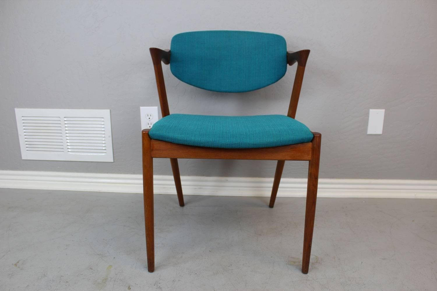 Set of eight teak Kai Kristiansen model 42 "Z" chairs. Iconic. Modern. Sleek short armrests and slightly rotational backrest. Original, cool blue fabric...in excellent condition.