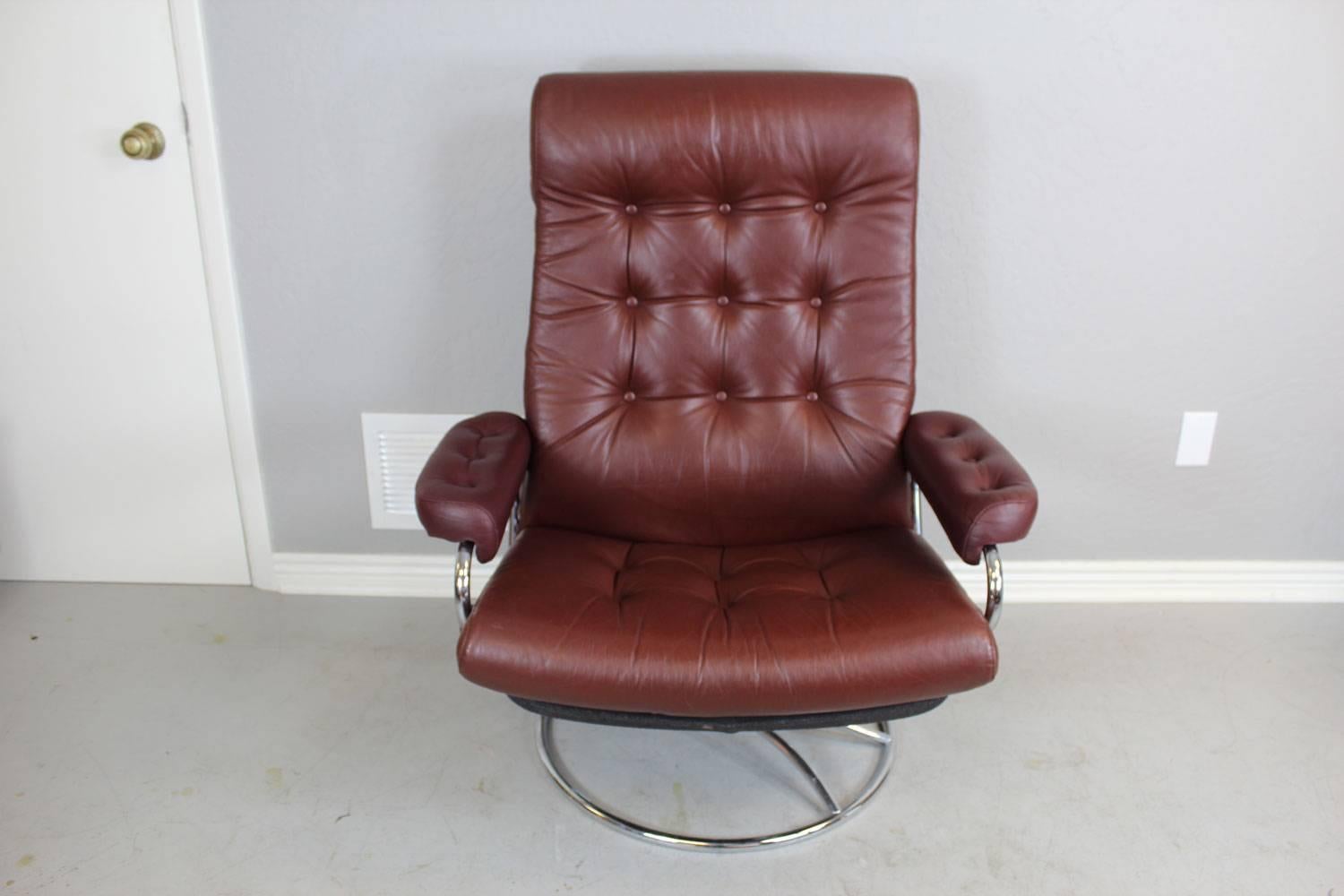 Mid-Century Modern chair and ottoman by Ekornes featuring tufted leather upholstery. This chair reclines and swivels. 

Ottoman dimensions: 21