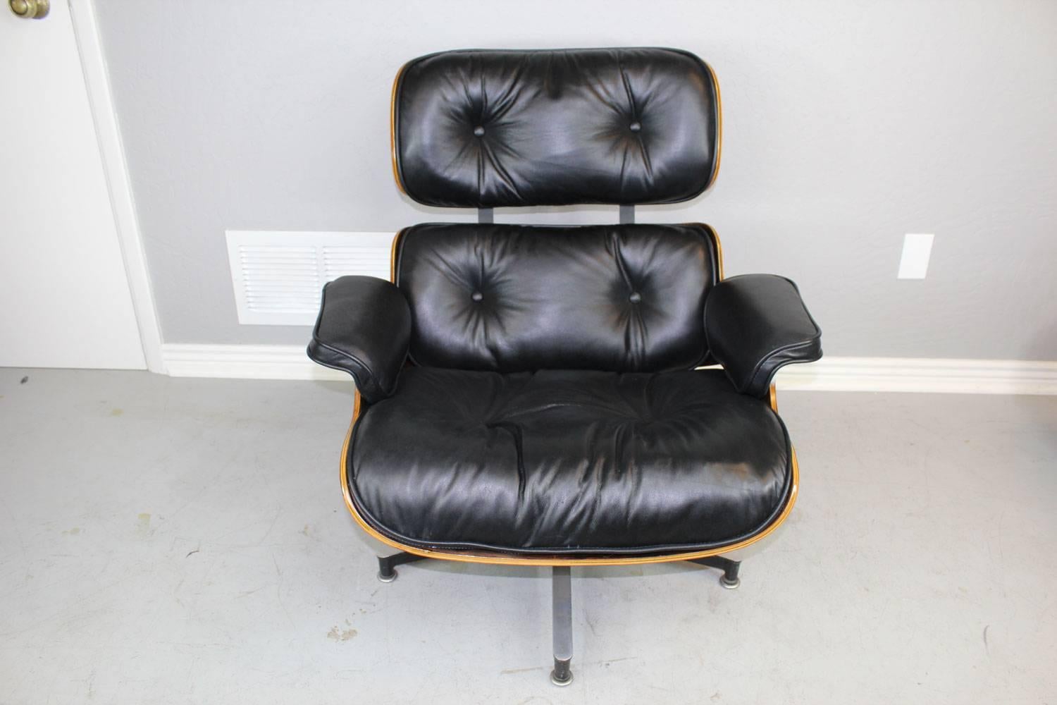 This is an exceptional black leather and dark wood 670 lounge chair and 671 ottoman designed, circa 1960s by Charles and Ray Eames and manufactured by Herman Miller. The rosewood has been professionally restored and reupholstered in a very high