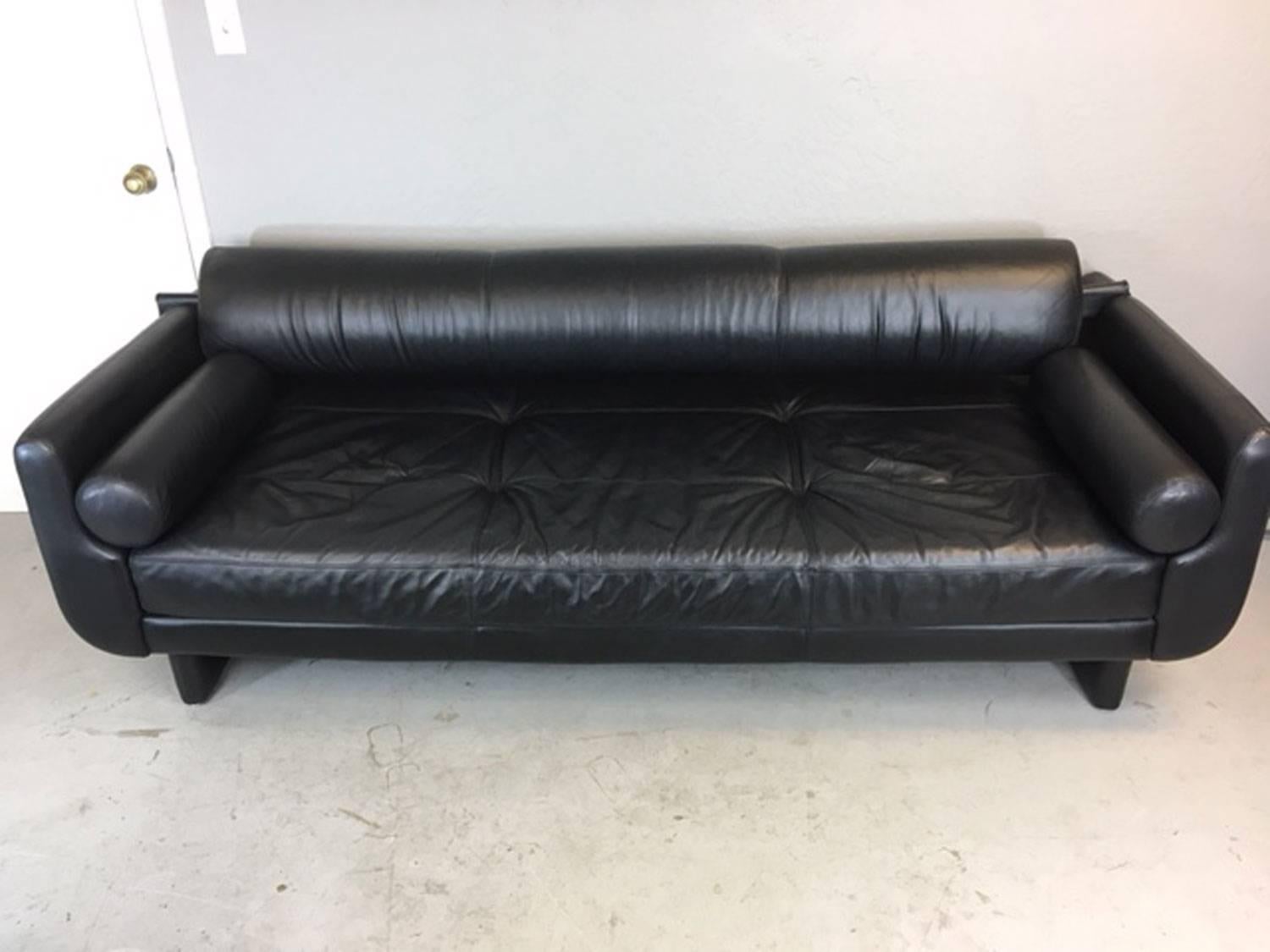 A Vladimir Kagan Matinee sofa made by American leather. A discontinued design that is reminiscent of an earlier Kagan sofa. The back cushion is removable to convert it into a daybed. This sofa also comes with two red Tootsie roll throw pillows that