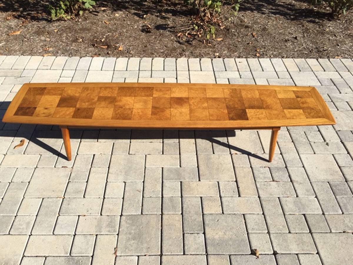 A fine Mid-Century Modern surfboard shaped coffee table by Tomlinson from the Sophisticate line. Maple with a bird's-eye checkerboard parquetry, circa 1950s.