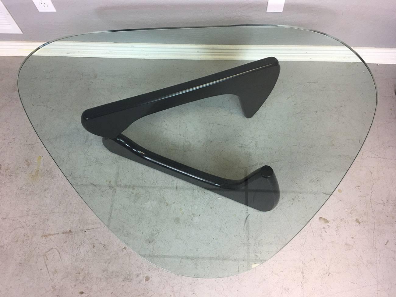 Isamu Noguchi coffee table, circa 2000s. Signed with maker's mark on base. Iconic. Ebony base and glass top are in exceptional condition.