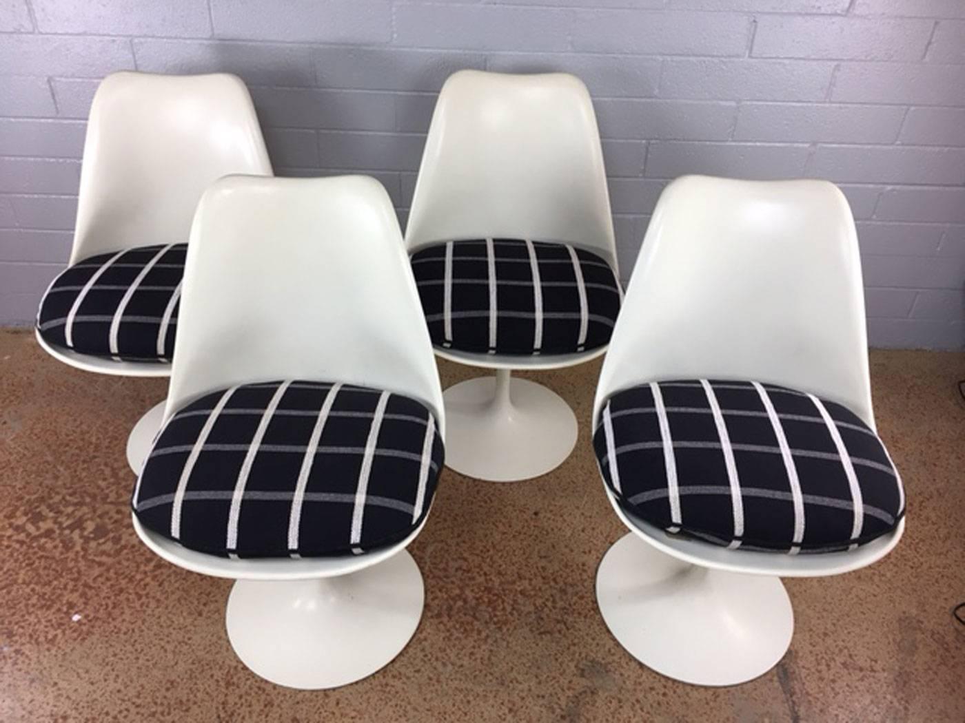 A set of four original Saarinen tulip chairs with black, crème and grey plaid cushions. Cushions are in really nice shape. Each chair has acceptable "lifewear", circa 1960s. Measures: Seat height is 16"H without cushions and 18"H