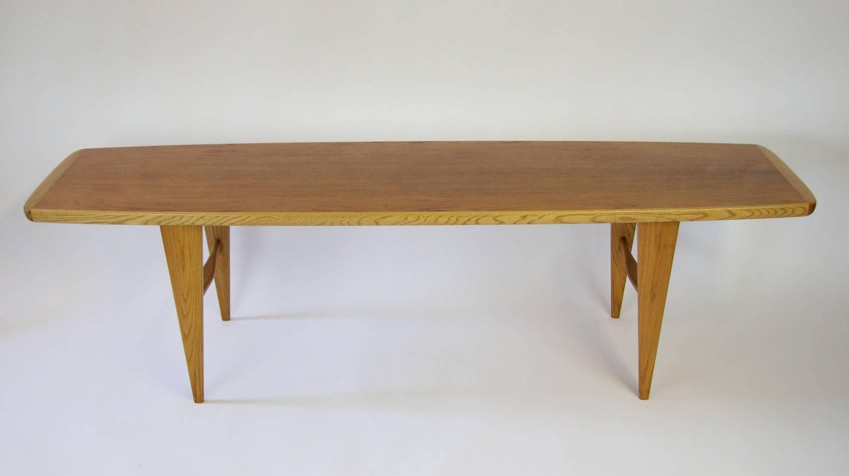 Svante Skogh teak and oak surfboard coffee table. Manufactured by Seffle Mobler of Sweden. Excellent condition. Beautiful tapered legs with sculpted supports.