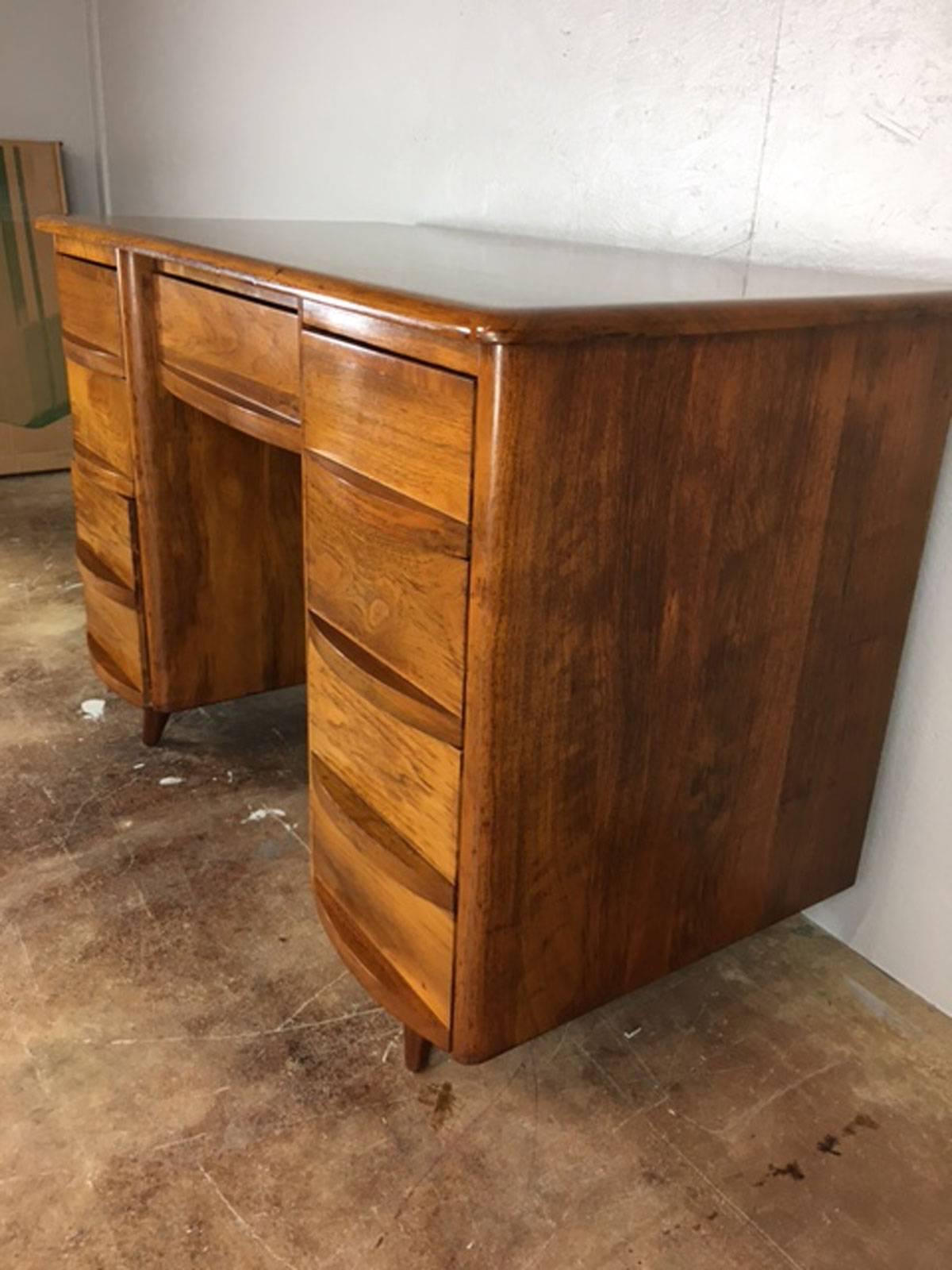 Heywood Wakefield style desk, with more style! Seven drawers. Finished back. Peg legs.  Circa 1950s.