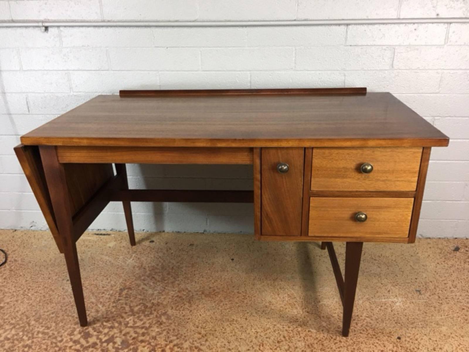 Unique drop leaf desk by Lane Altavista in walnut. Refinished. Clean lines. circa 1960s.Drop-leaf extends and adds another 16