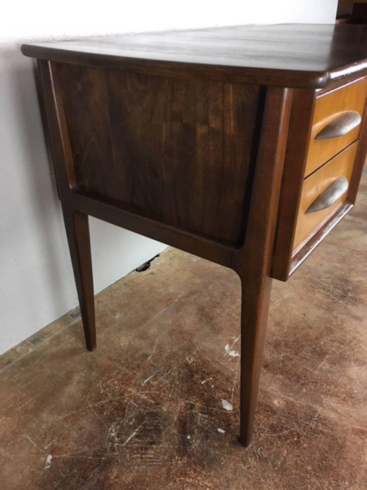 Unique Danish desk in pecan and walnut with external legs and frame. Note the curved wooden pull handles. Refinished and rich.
