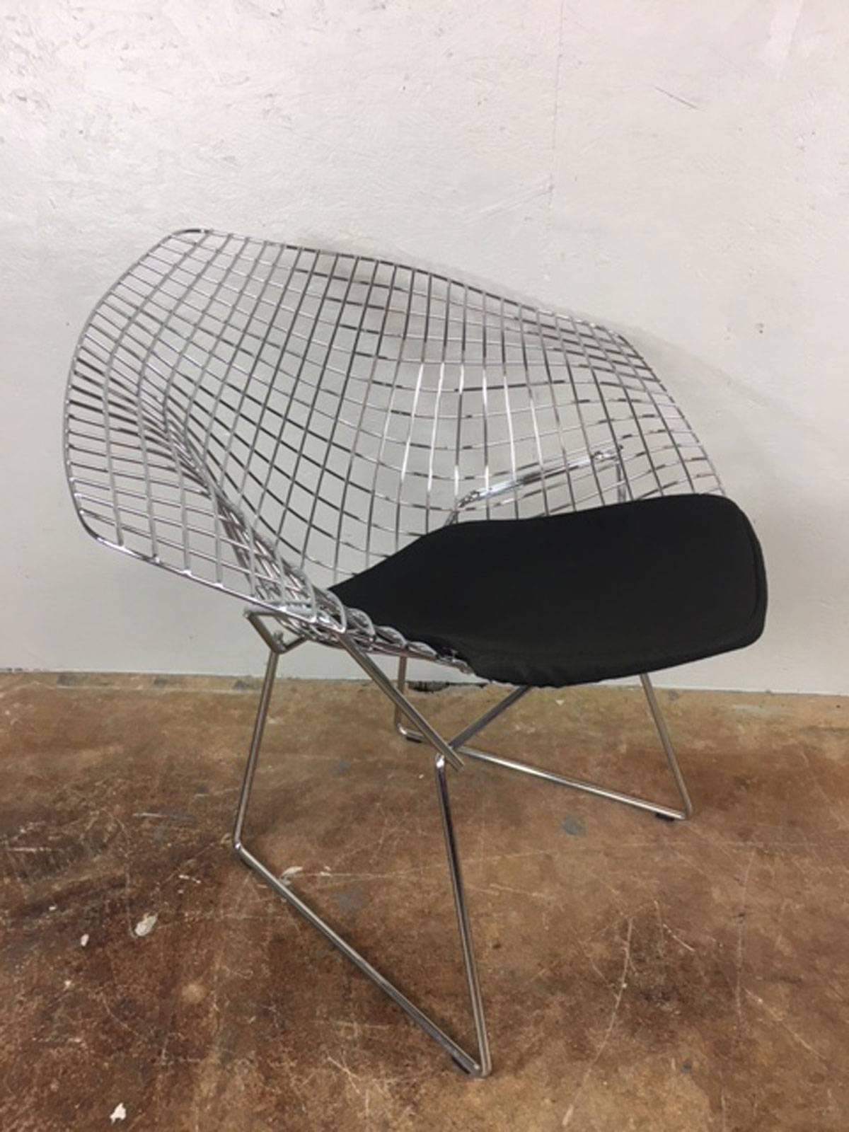 Harry Bertoia diamond chair with black wool pad manufactured by Knoll. Stainless steel and welded steel rod construction. Two chairs available. Price is per chair. Measure: Seat height is 16 inches.