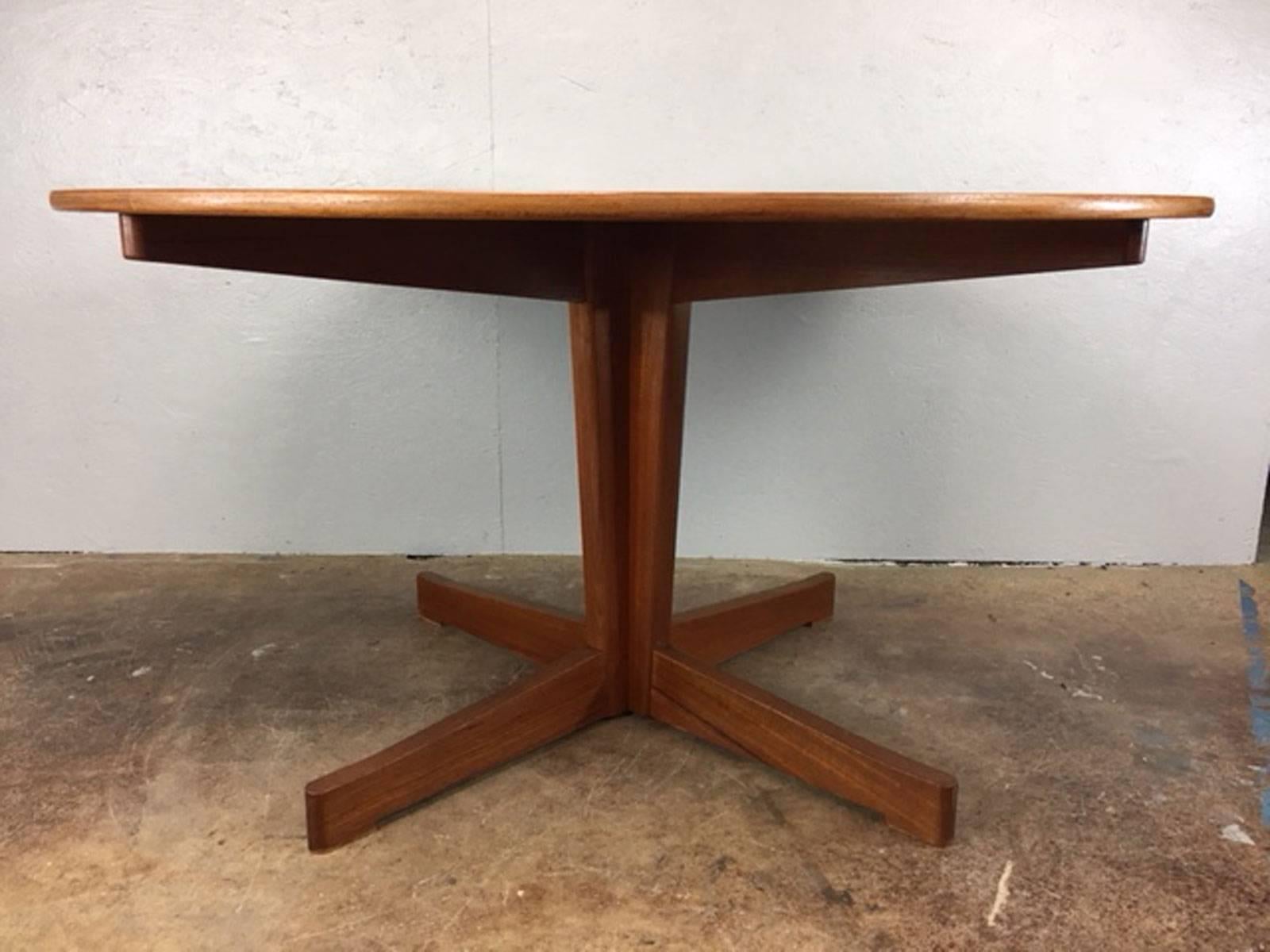 Very high quality round teak dining table on a four star base. Original excellent condition. Superb graining. Attractive table.