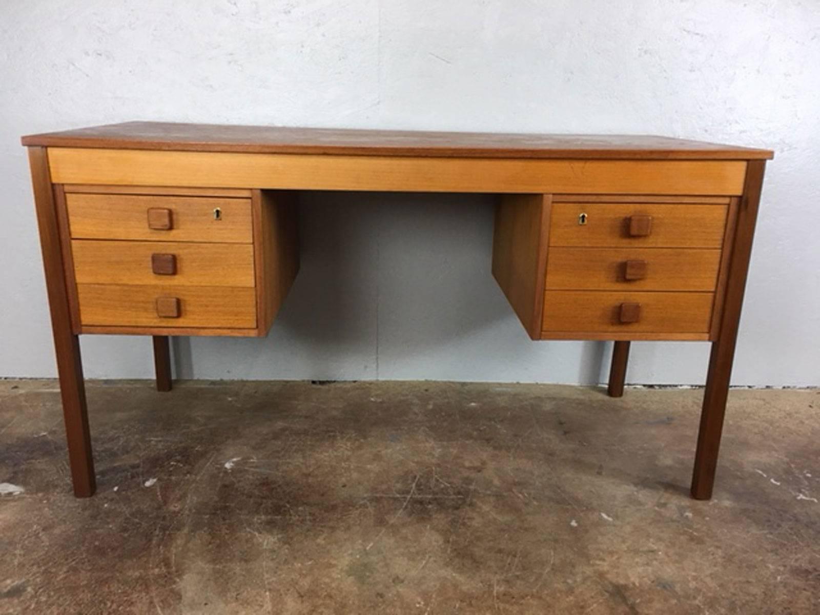 Teak desk with six drawers. Two locking drawers with key. Solid teak pulls. Original very good condition.