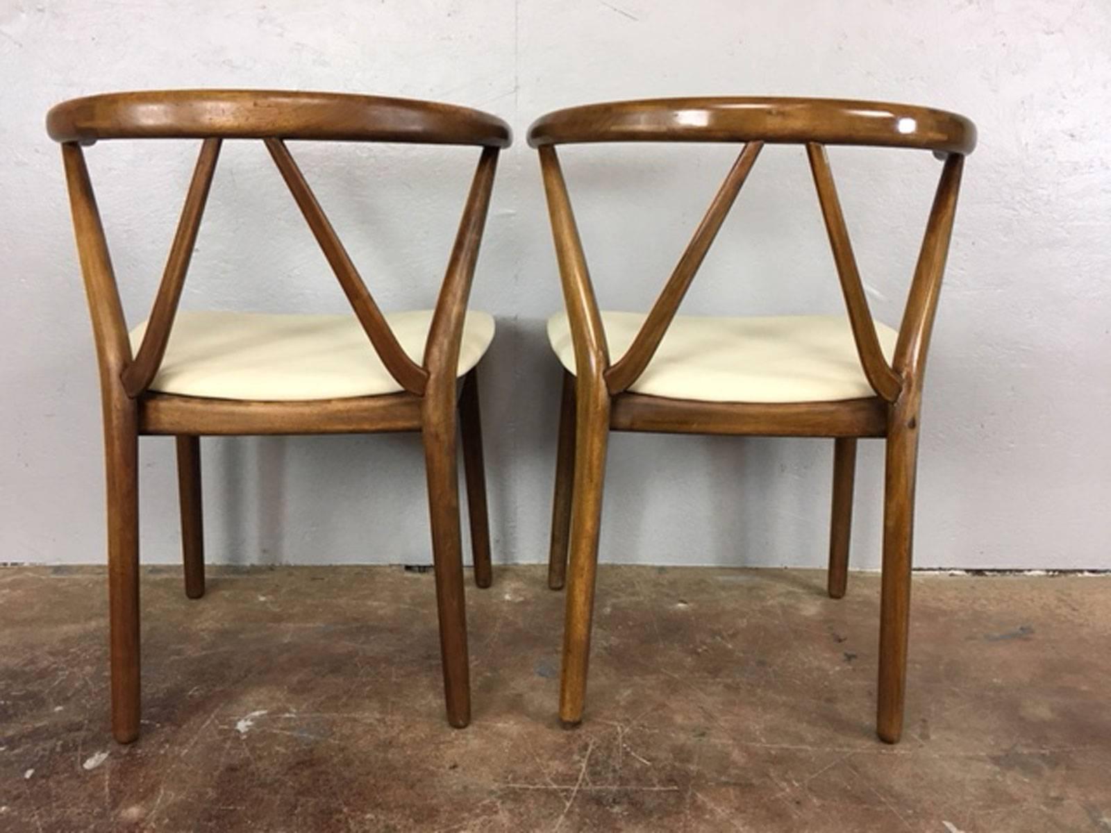 Designed by Henning Kjærnulf for Bruno Hansen, Denmark, circa 1960s. Solid teak frames with curved backrests and superb joinery. Newly upholstered in a cream or neutral leather. One photo depicts a small, repaired hairline fracture. Stamped Bruno