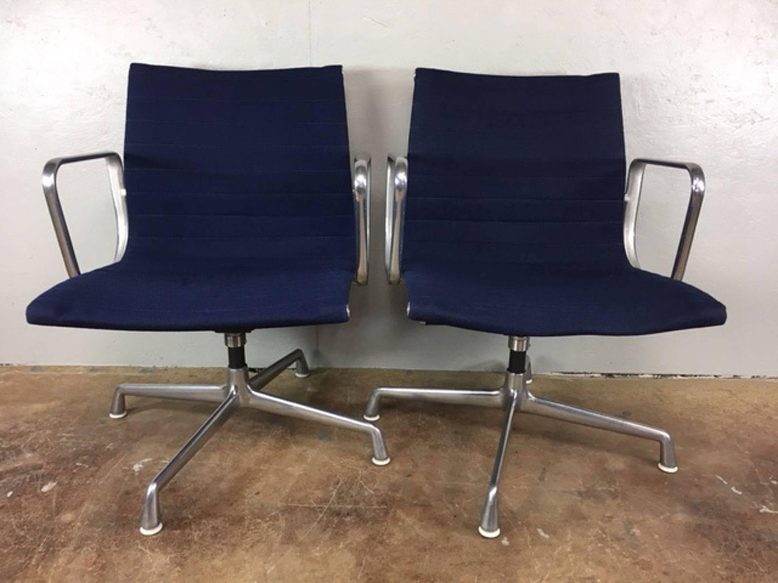 Pair of original Charles Eames soft back aluminum management chairs by Herman Miller. Brushed aluminum base on a four star base with glides. Original fabric. No rips, tears, holes, or unusual wear. Price is for the pair.