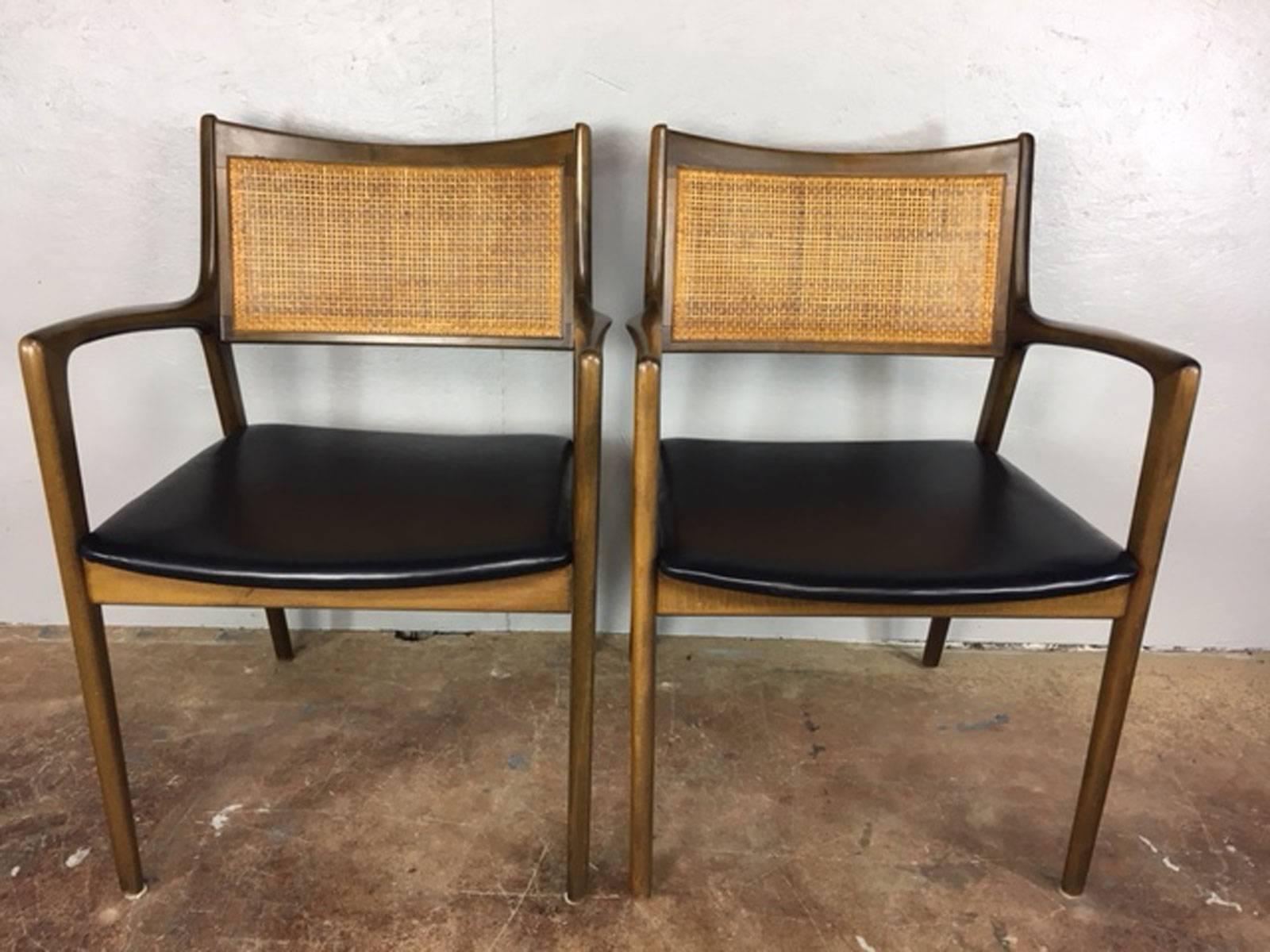 Pair of 1960s cane back, leather, and walnut side or dining chairs by Erik Ekselius of Sweden. New leather.

Measure: Seat height is 17.5 inches.