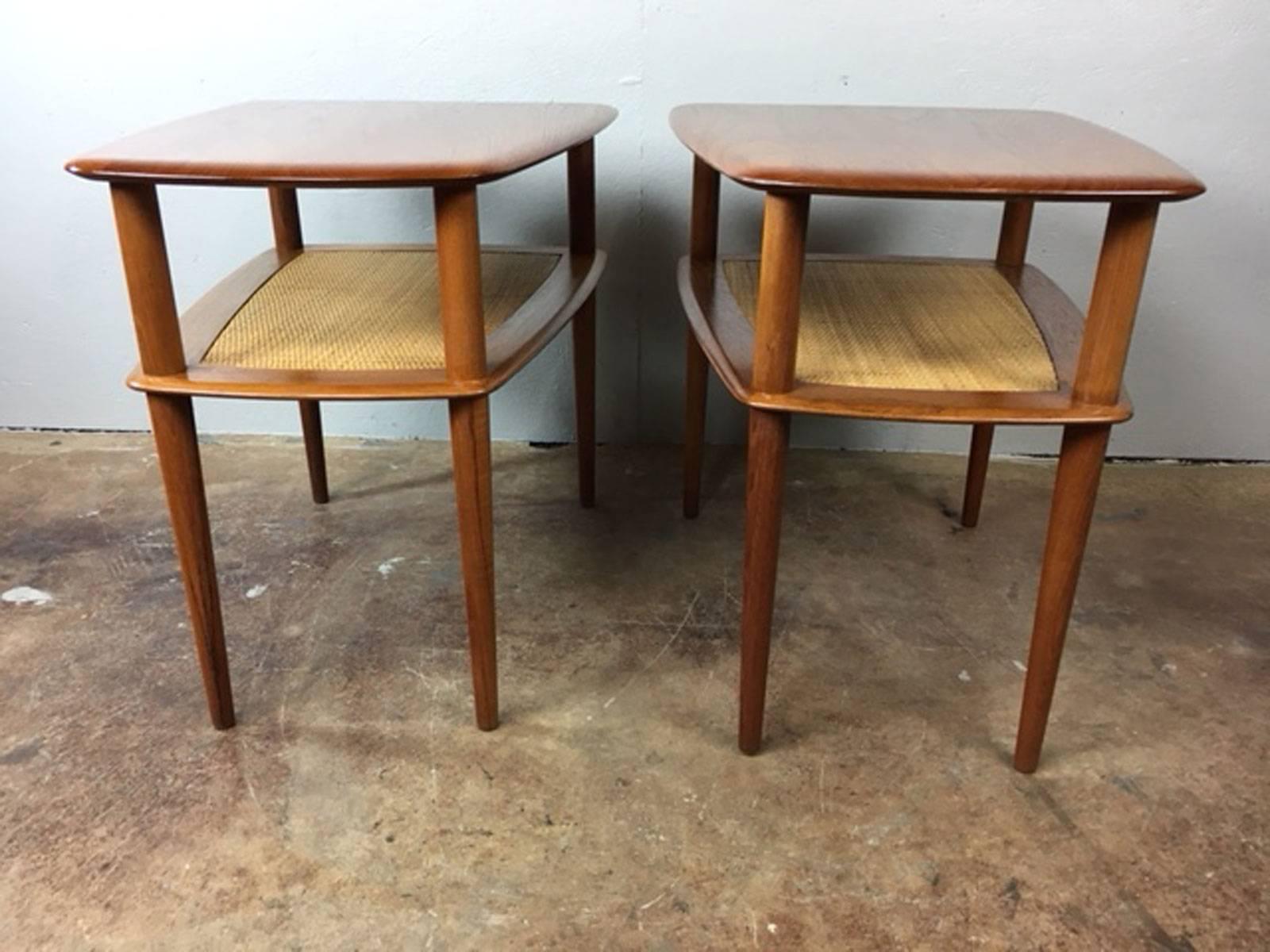 Solid teak end table pair designed by Peter Hvidt and Orla Mølgaard-Nielsen for France & Sons. The lower shelves retain their original caned inserts. Each piece includes the France & Sons manufacturing tag.