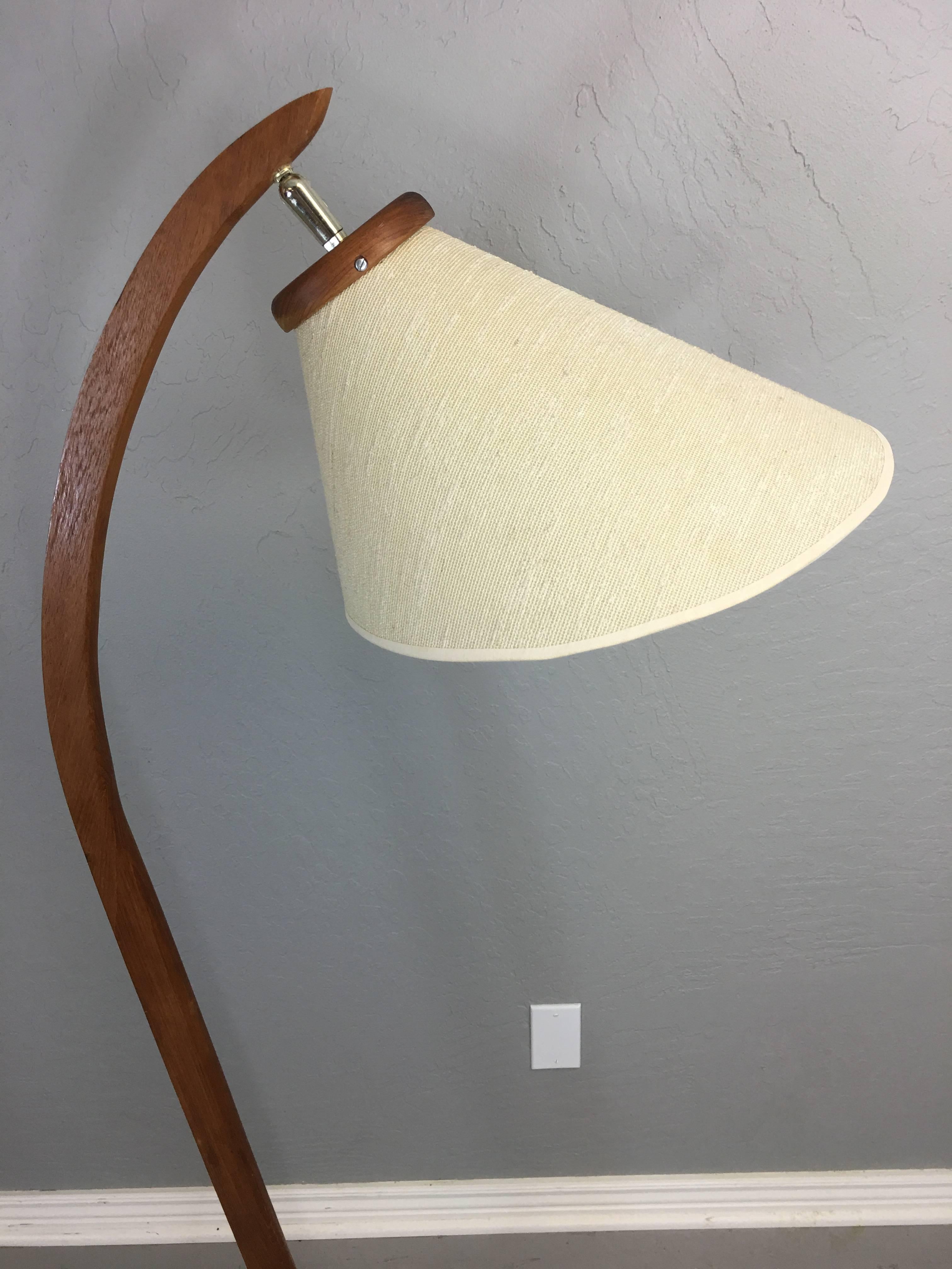 Danish inspired teak floor lamp made in Canada. No other information to identify maker. The flared shade is original and without stains. The switch is under the shade. It stands 60