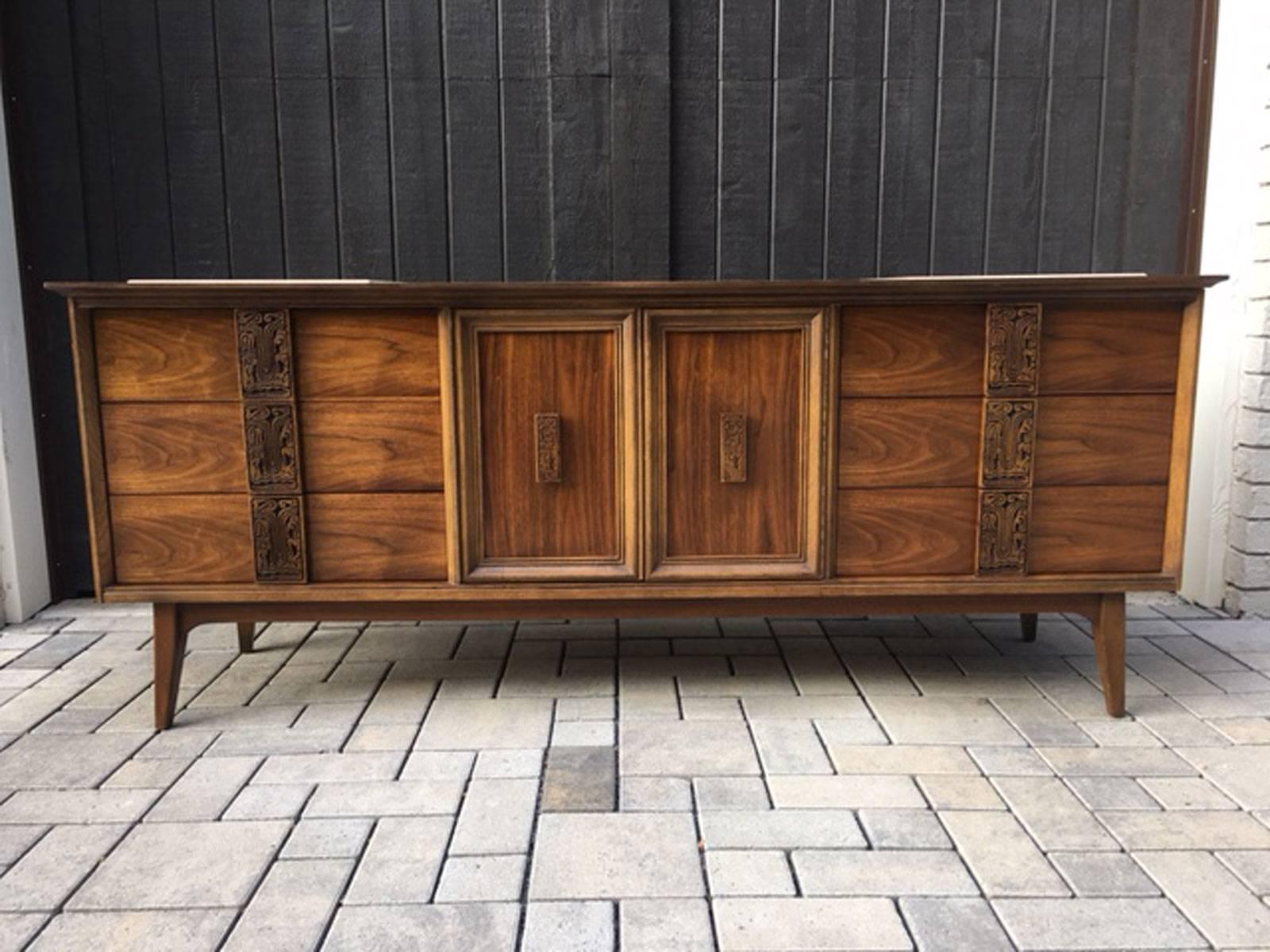 Exquisite nine drawer dresser in walnut from the Mayan group by Bassett.  Expertly refinished.  This dresser includes two inset stone pieces that are perfect for displaying two lamps or pieces of art while eliminating the worry of scratching the